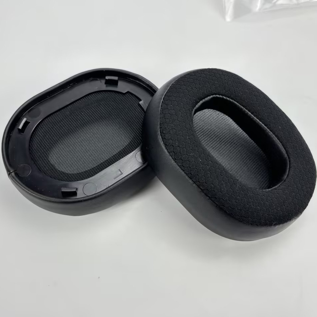 Due cuscinetti auricolari neri per cuffie. Sfondo bianco.