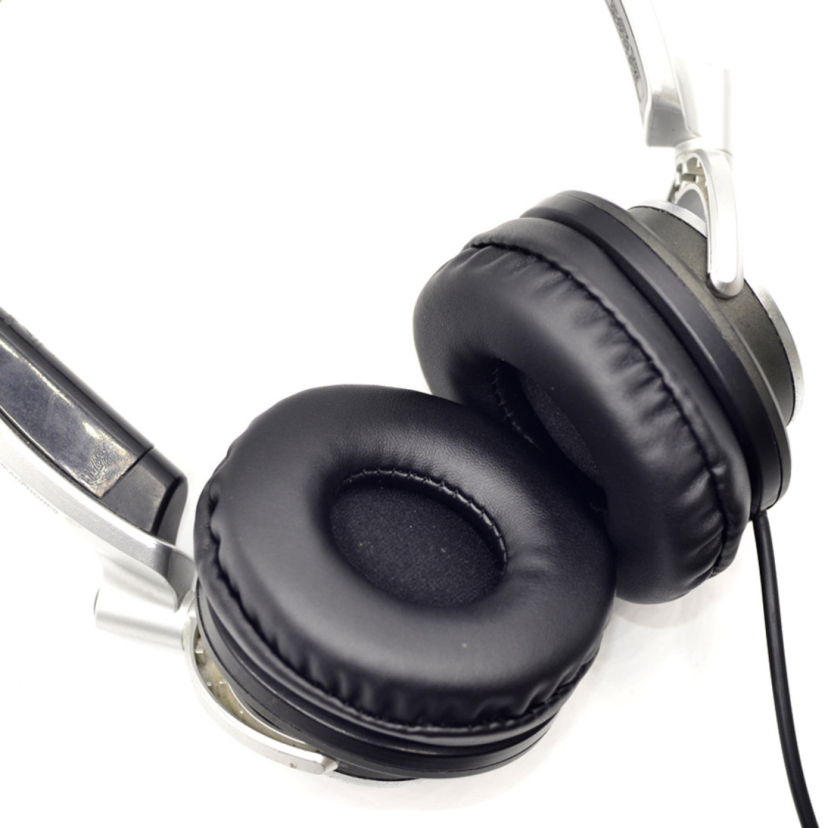 Cuscinetti auricolari neri su cuffie, con metallo color argento e cavo nero.