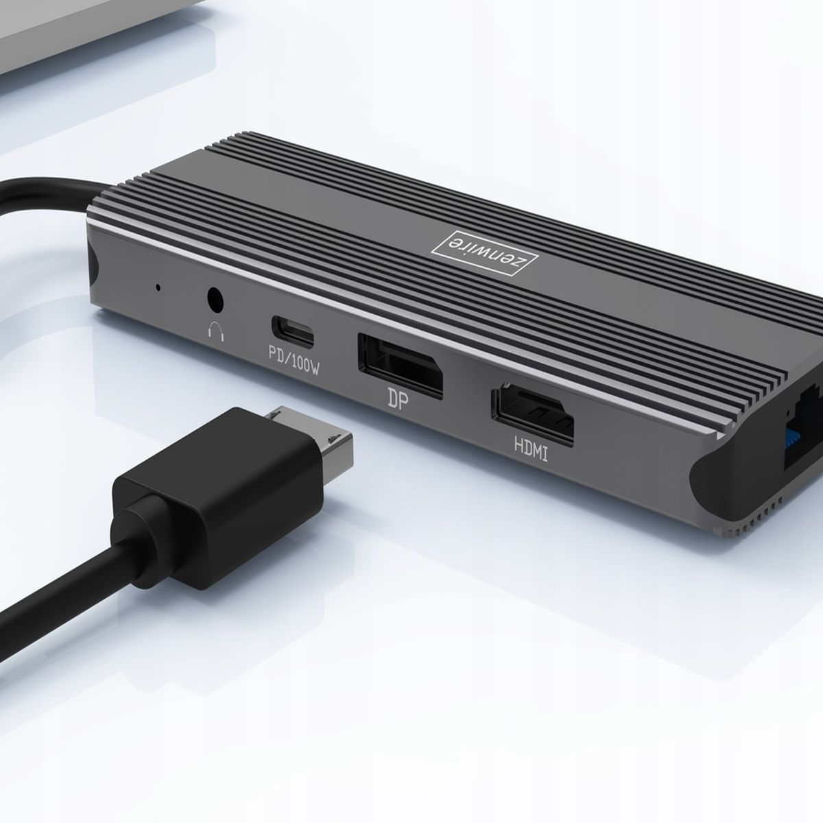 Srebrny hub z portami: PD/100W, DP, HDMI i czarny kabel podłączony do laptopa.