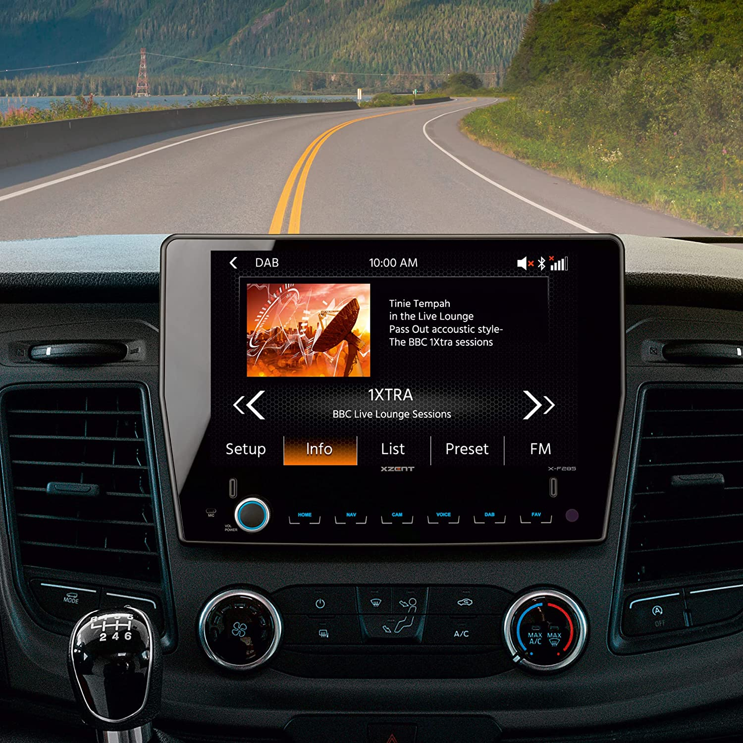 Auto-Innenraum mit Armaturenbrett, das eine Radioschnittstelle zeigt, Straßenansicht durch die Windschutzscheibe.