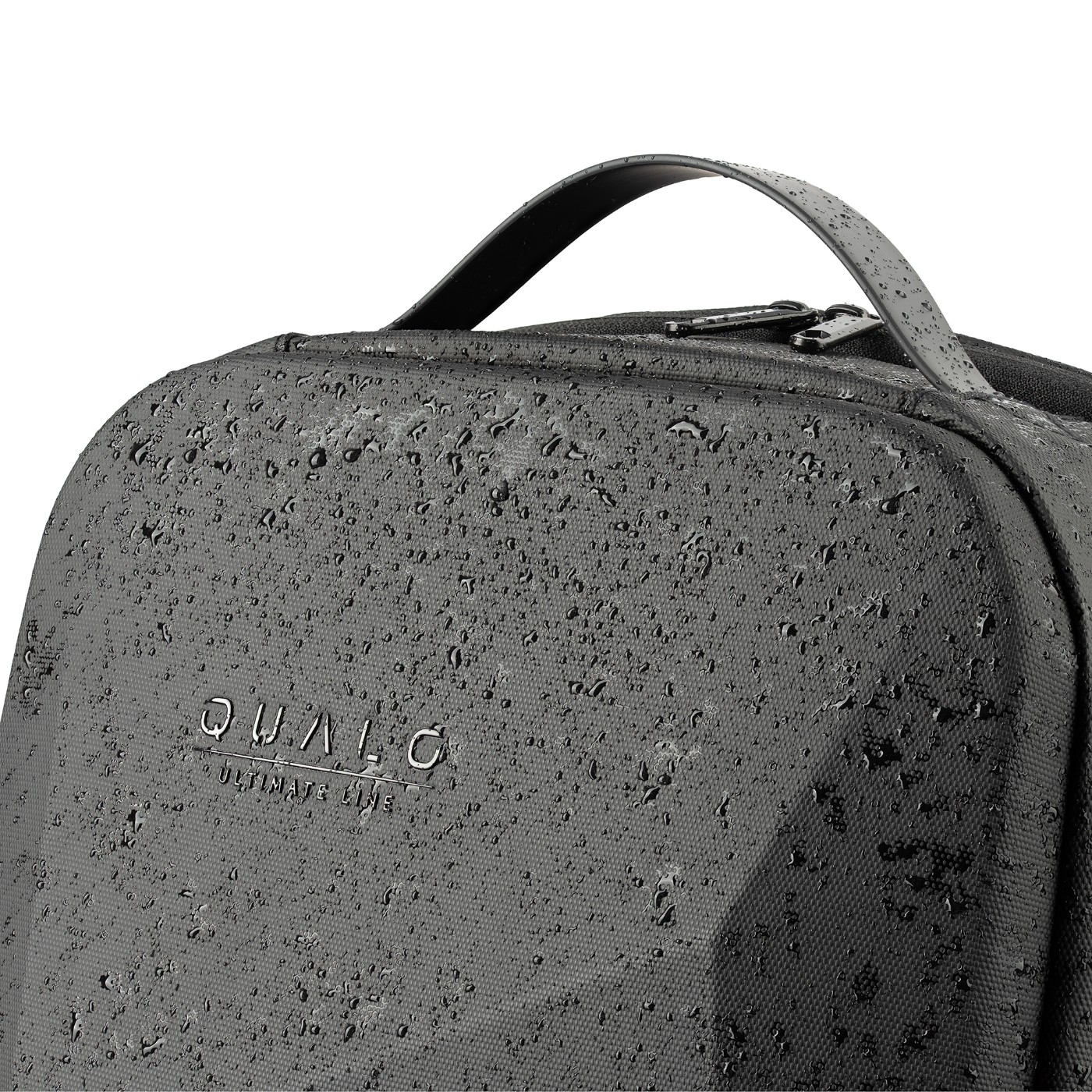 Zbliżenie czarnego plecaka z kroplami wody. Widoczna nazwa marki QUALO.