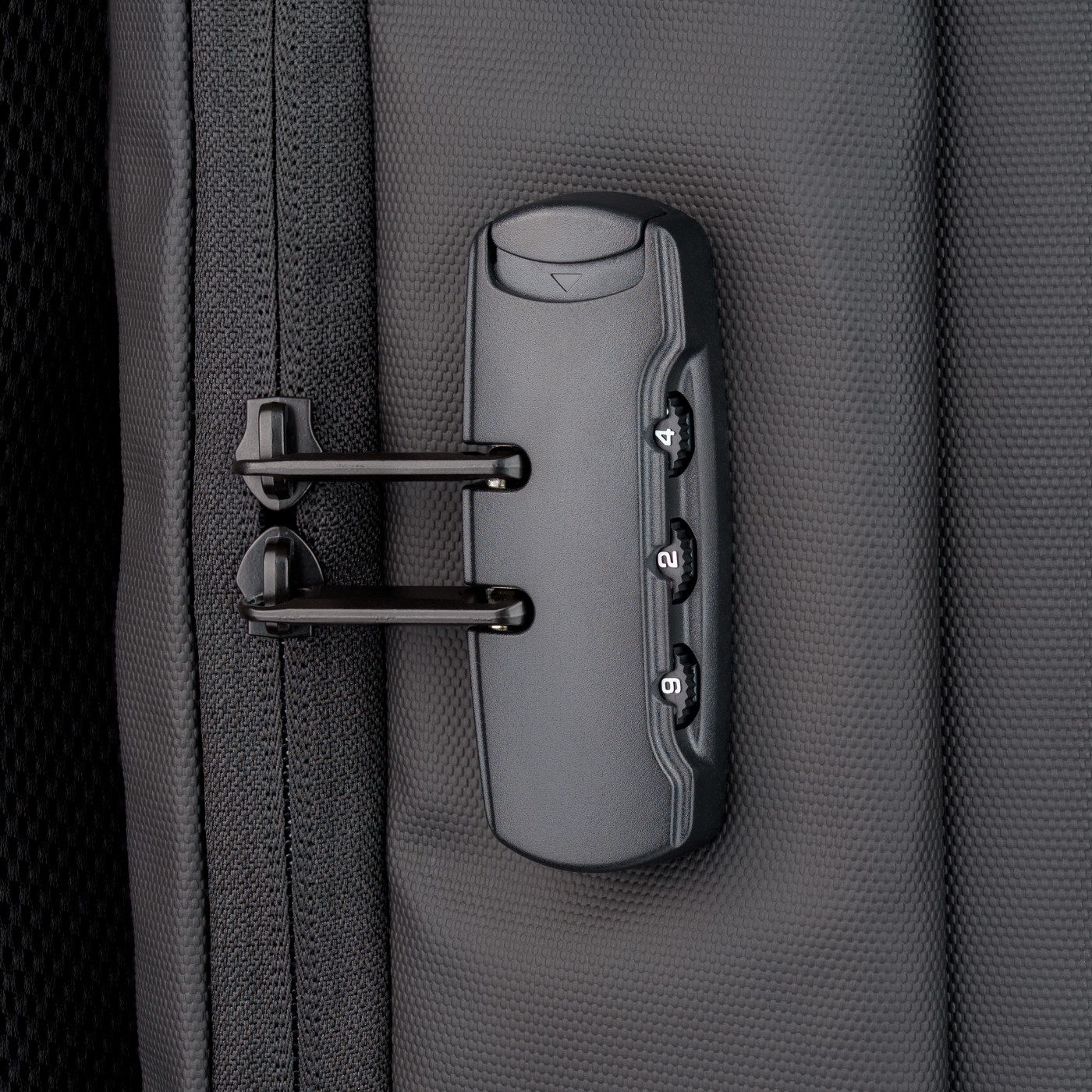 Zbliżenie zamka szyfrowego na czarnym plecaku, z widocznymi numerami.