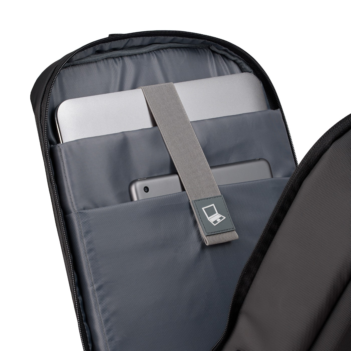 Wewnątrz czarnego plecaka: laptop, telefon i szary pasek. Ciemnoszare wnętrze. Białe tło.