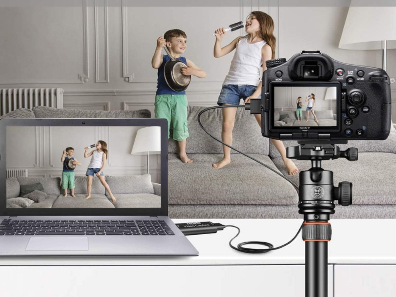 Dzieci śpiewają do mikrofonów, wideo nagrane na kamerze i wyświetlane na laptopie.