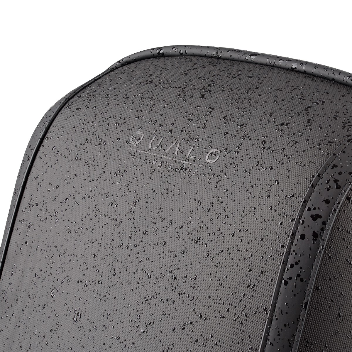 Zbliżenie szarego plecaka z kroplami wody.