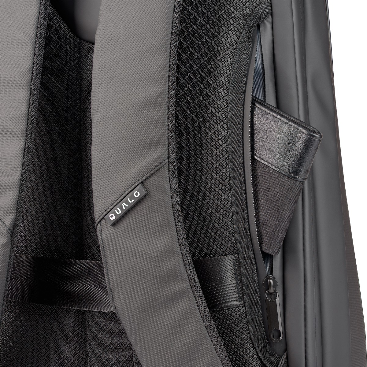 Szczegół plecaka z czarnym portfelem w bocznej kieszeni. Torba jest ciemnoszara z czarną siatką.