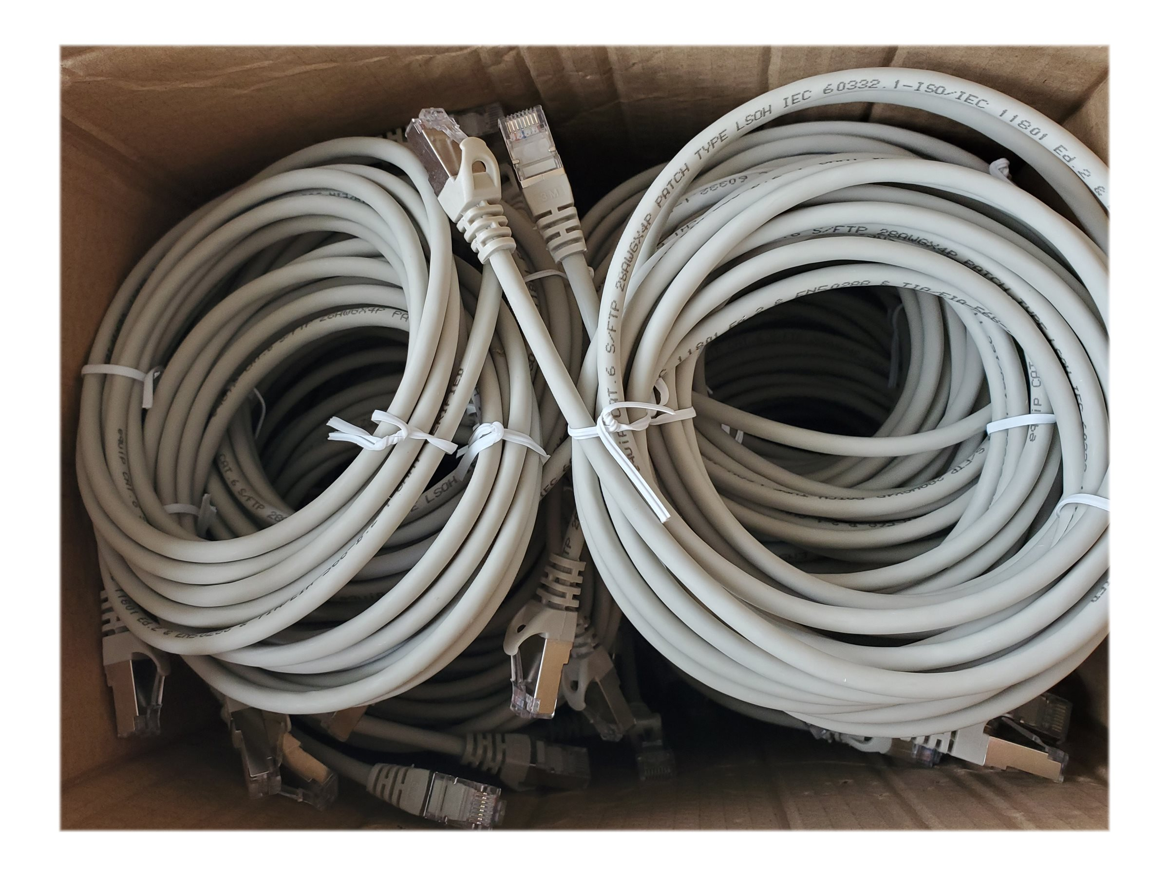 Diversi cavi Ethernet grigi sono arrotolati e raggruppati in una scatola di cartone.