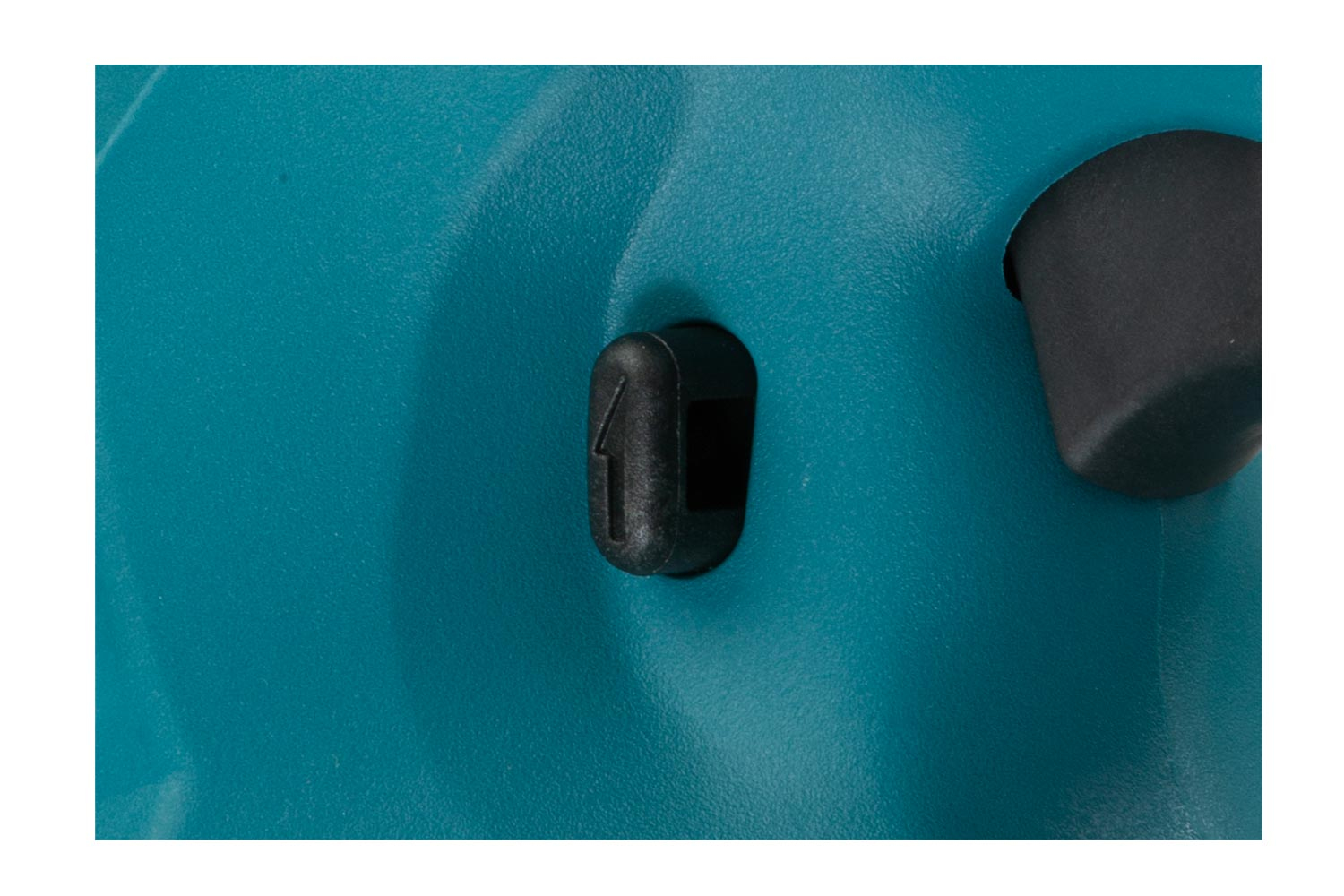 Primo piano di uno strumento turchese con un pulsante nero.