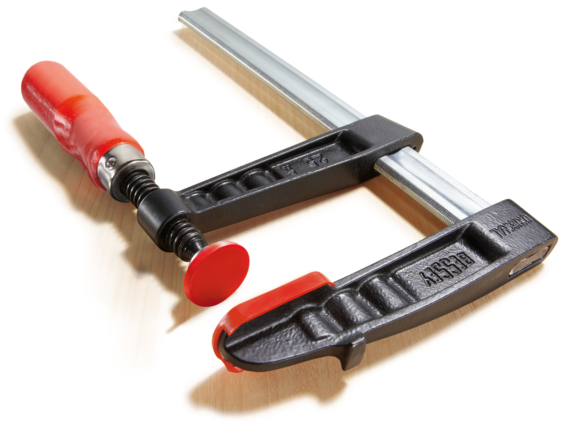 Schwarze und rote Bessey-Klemme auf einer Holzoberfläche.
