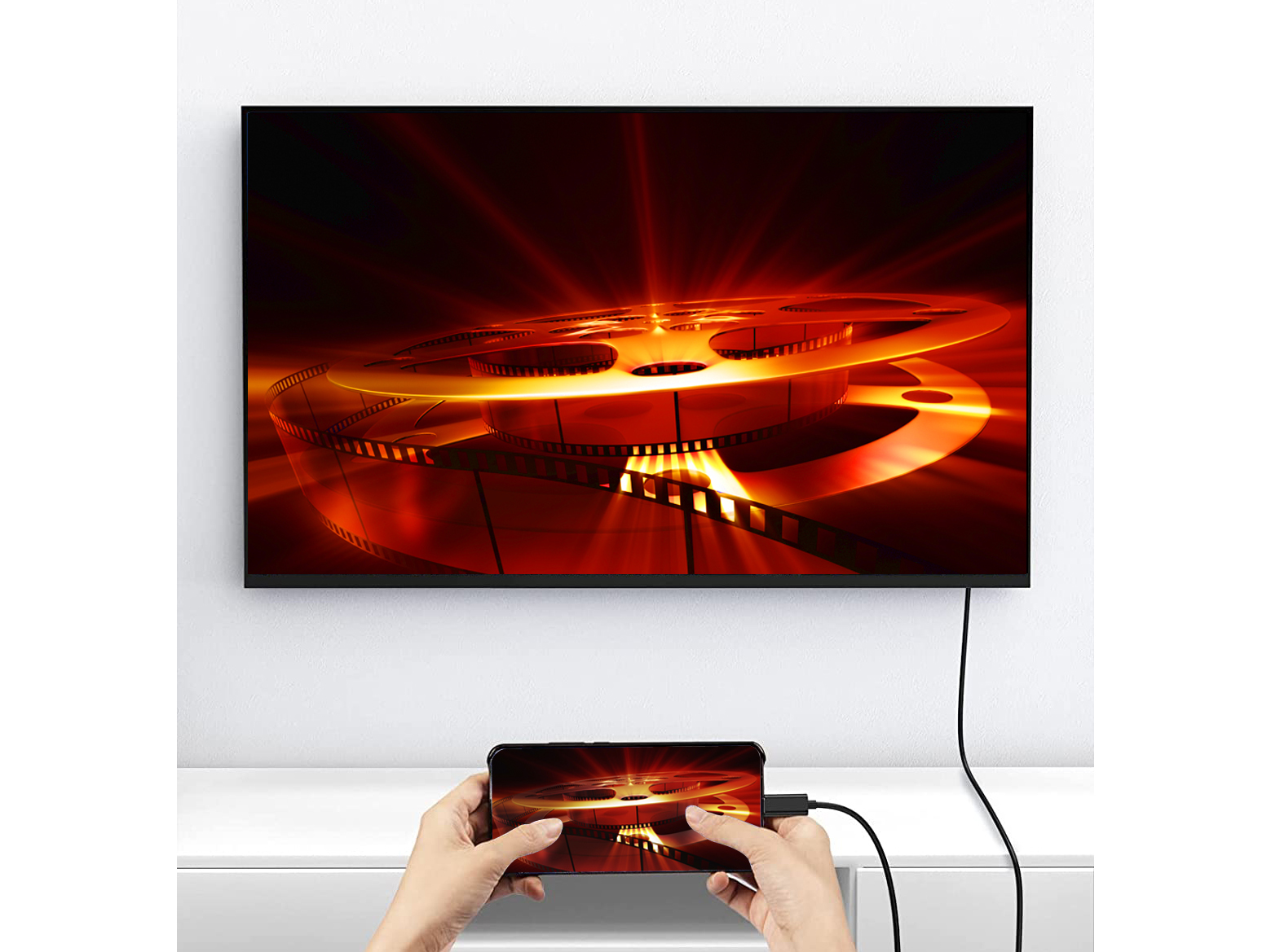 Obraz przedstawia czarny telewizor ze szpulą filmową i telefon odzwierciedlający tę samą treść.