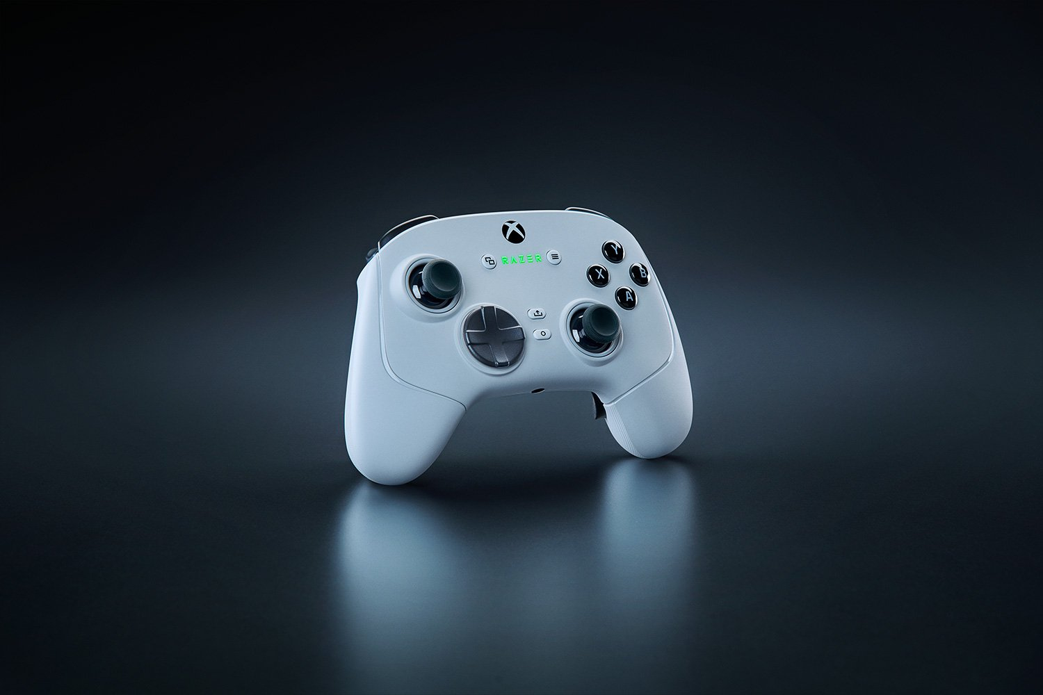 Karanlık bir yüzey üzerinde beyaz Razer Xbox kontrolcüsü, üstten aydınlatılmış. Düğmeler ve başparmak çubukları.