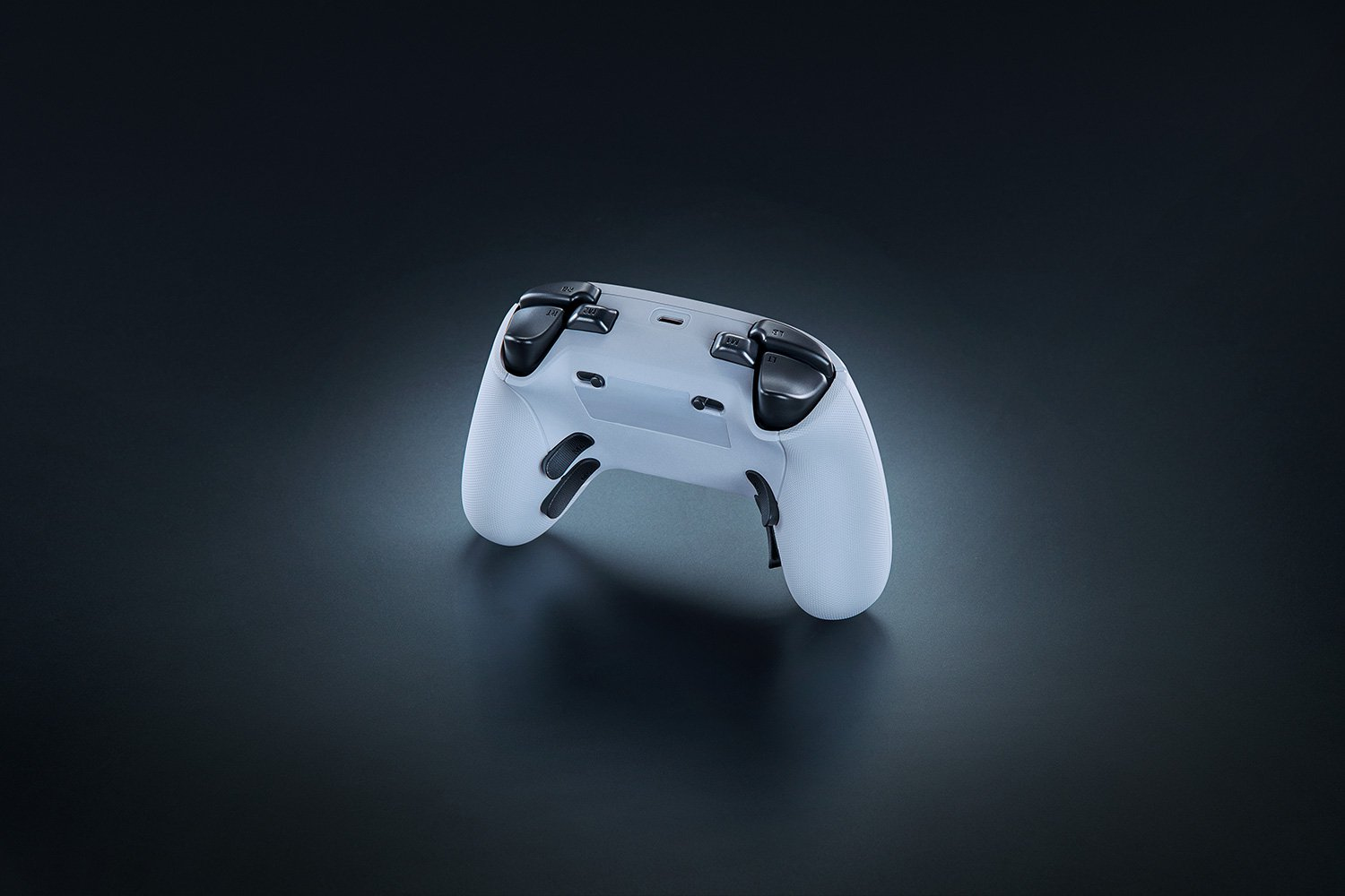 Beyaz Razer Xbox kontrolcüsü, arka görünüm. Siyah tetikler ve tamponlar.