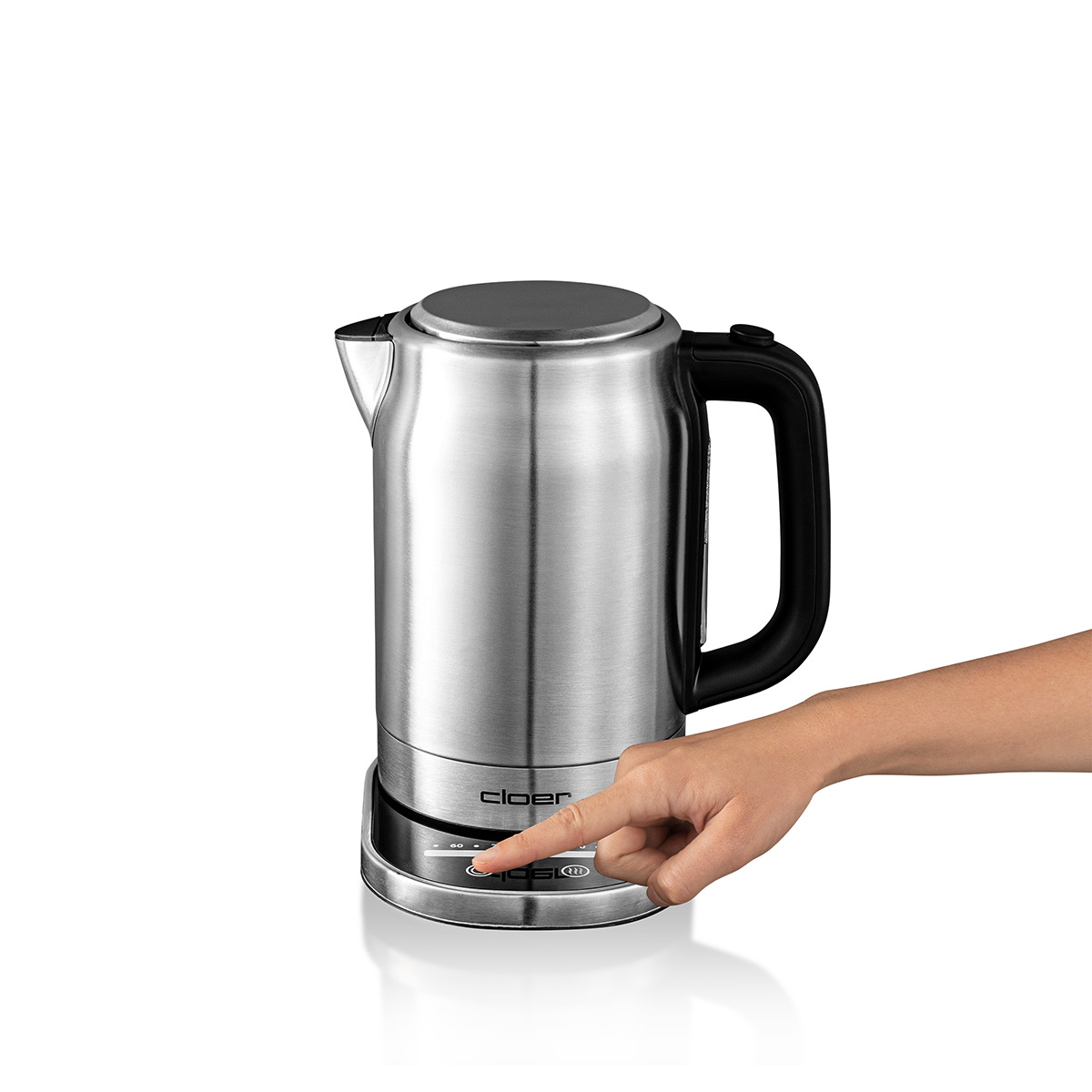 Dłoń naciska przycisk na podstawie czajnika. Przycisk ma wokół siebie światła.