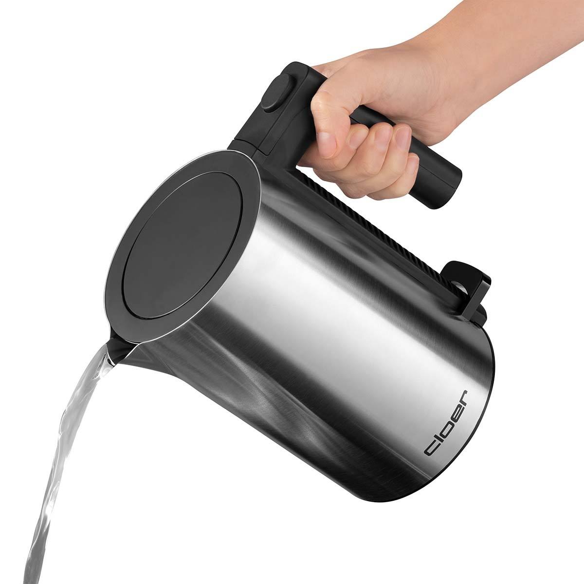 Un bollitore argentato e nero versa acqua. Una mano tiene la maniglia.