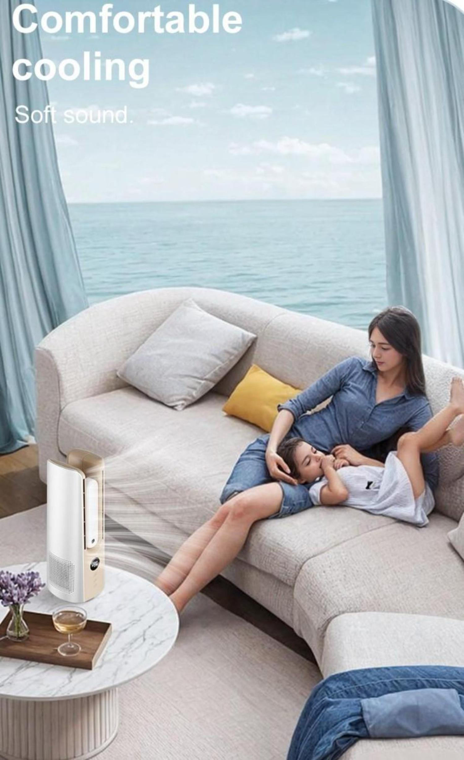 Eine Frau und ein Kind entspannen sich auf einem Sofa, mit einem Luftkühler und einem Tisch mit Getränken daneben.