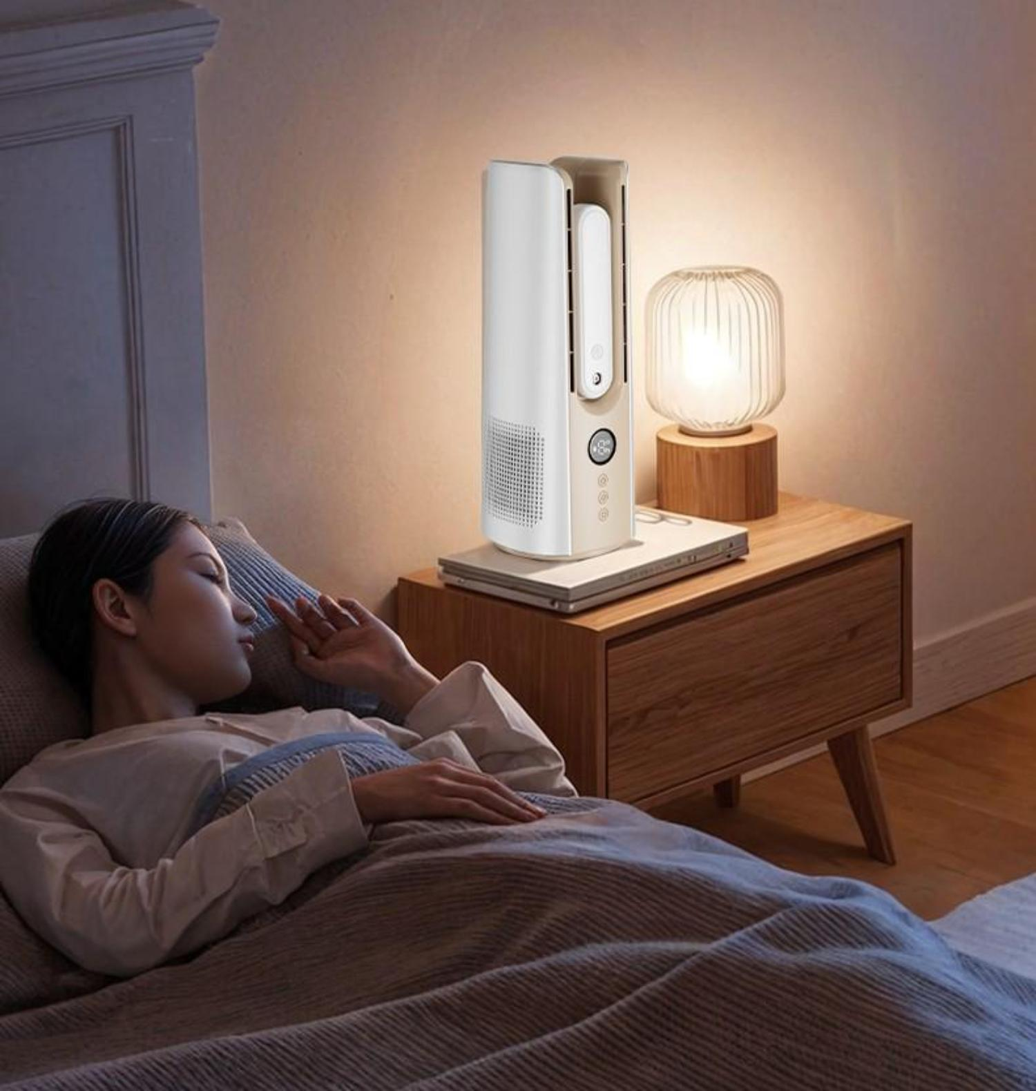 Eine Frau schläft im Bett, in der Nähe steht ein beige-weißer Ventilator.