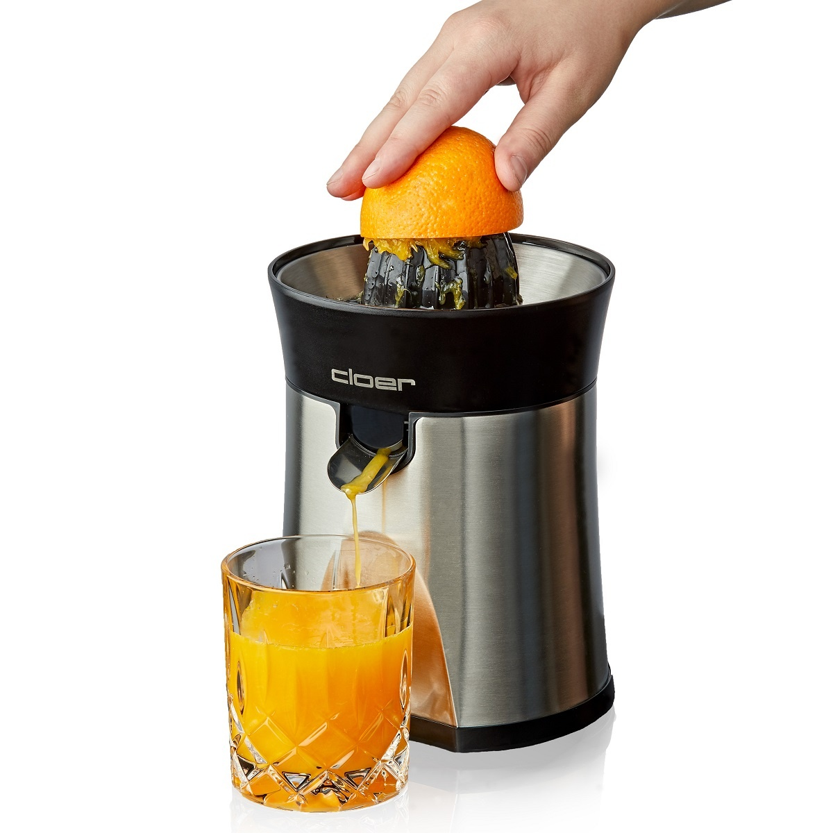 Eine Person, die eine Orange mit einem silbernen und schwarzen Entsafter in ein Glas presst.