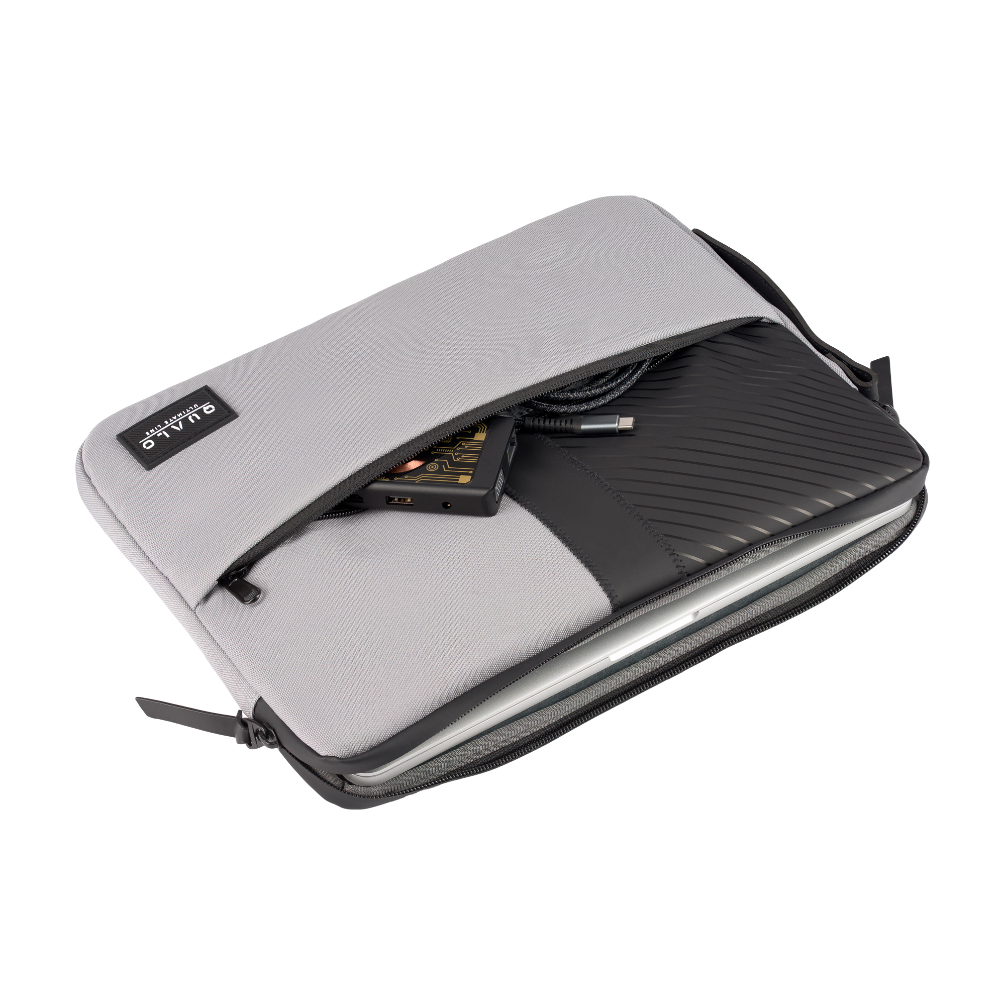 Otwarta szara torba na laptopa z laptopem, czarnym urządzeniem i kablem w środku. Białe tło.