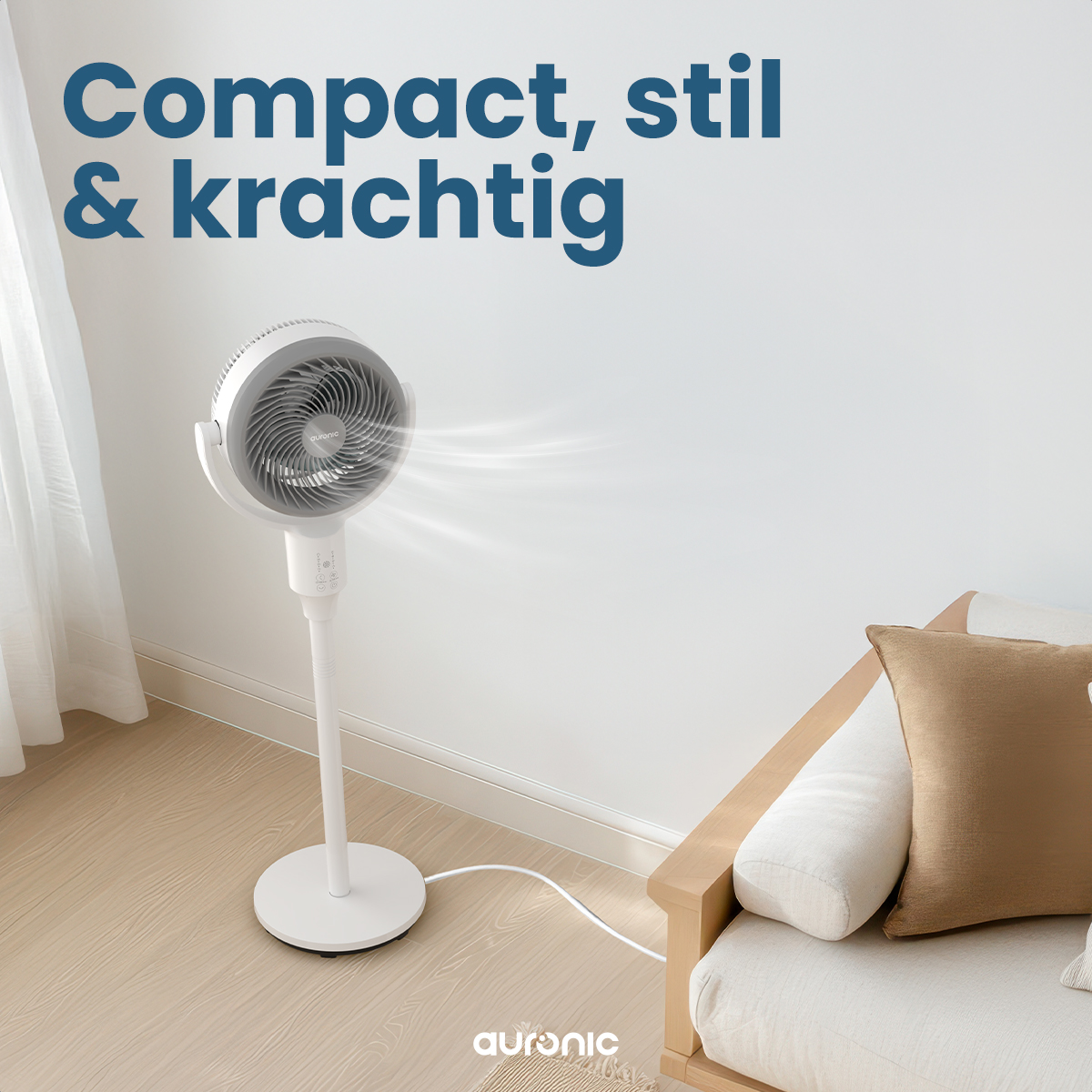 Weißer Ventilator, der Luft bläst. Text: Kompakt, stilvoll & kraftvoll. Weiße Wand, Vorhang, Couch.