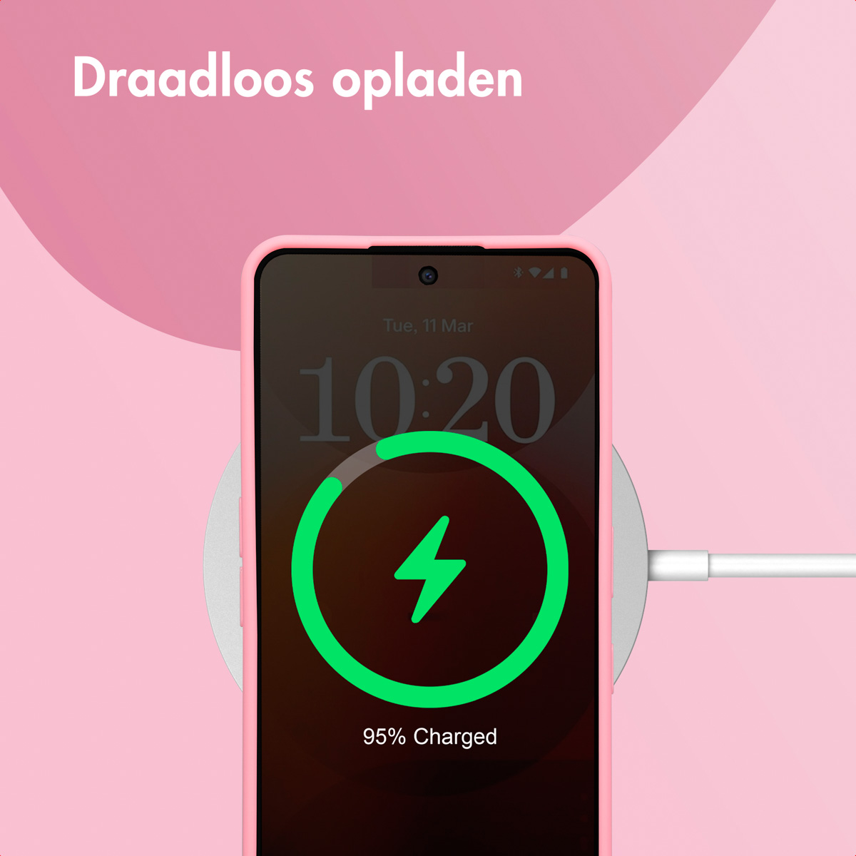 Een telefoon in een roze hoesje dat draadloos oplaadt, met een oplaadsymbool. Roze achtergrond.