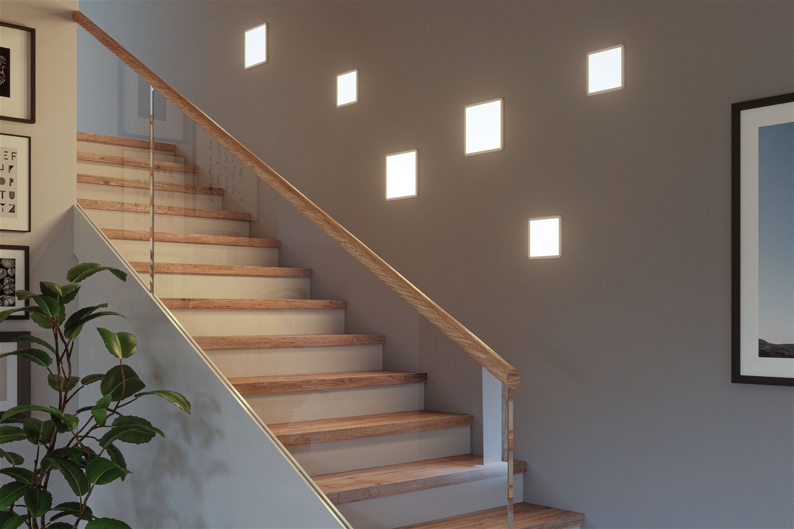 Treppe mit Holzstufen, Glasgeländer und rechteckigen Lichtern an einer grauen Wand. Pflanze links.