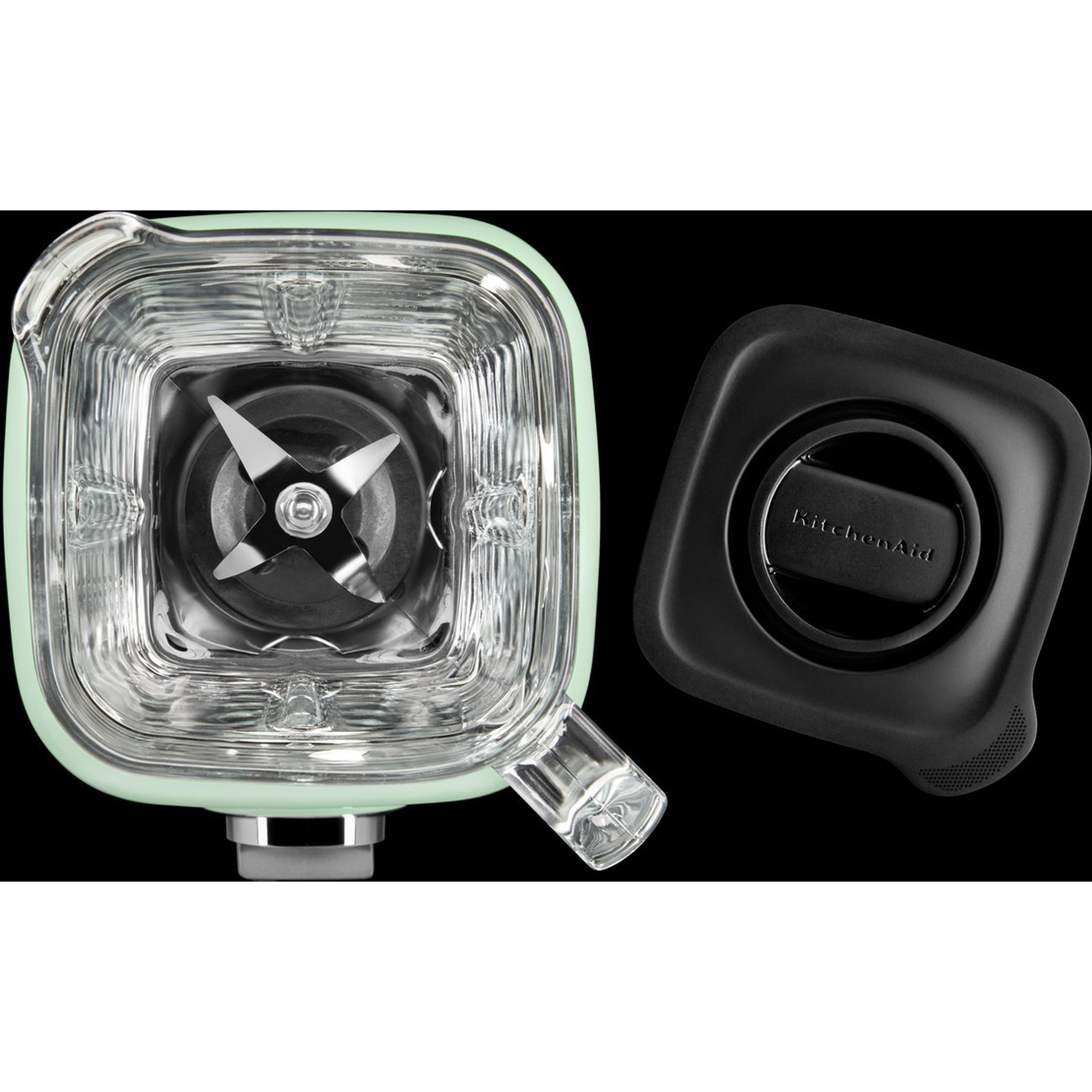 A blender's glass jar, blades, and black lid. The jar is mint green.