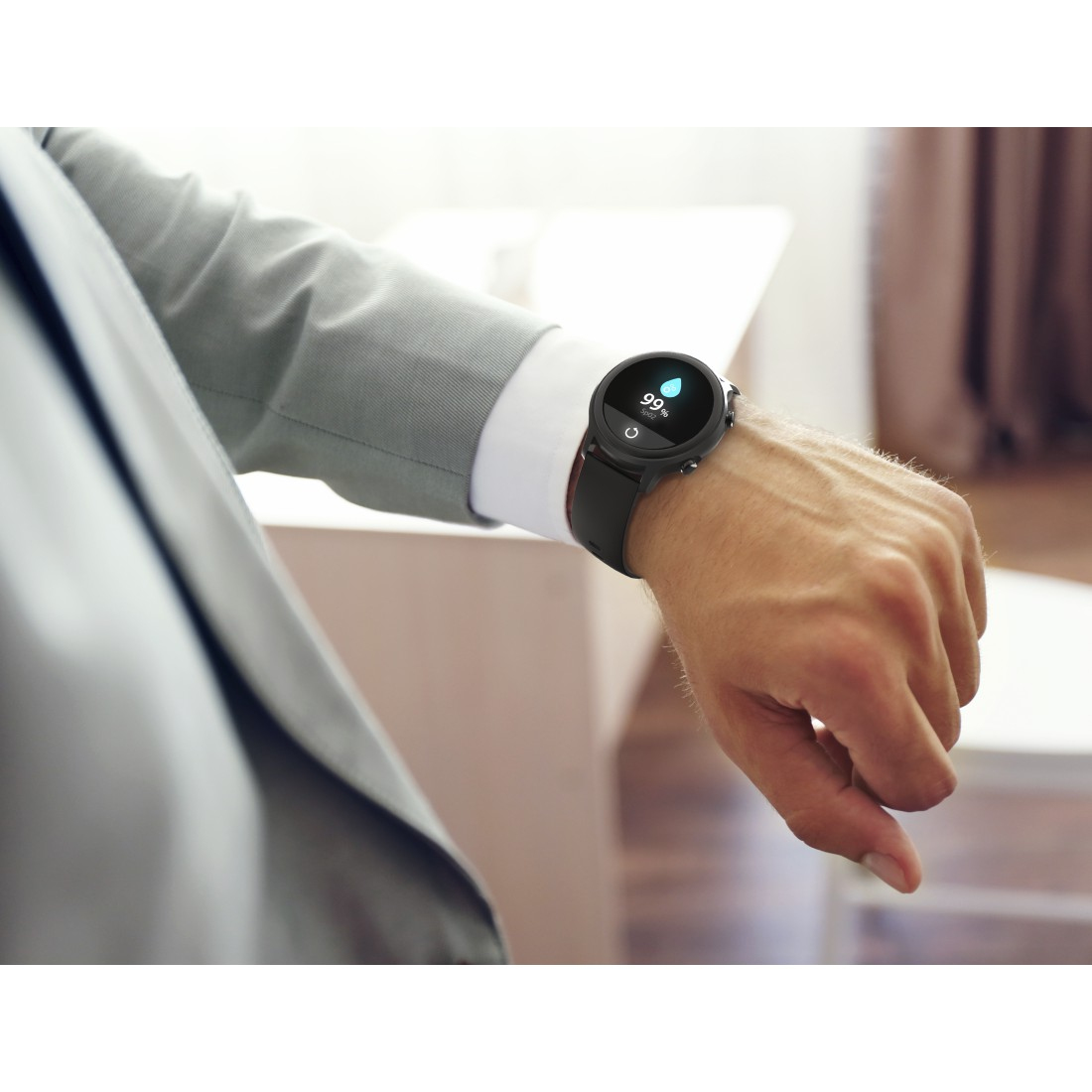 Osoba nosząca czarny smartwatch, nadgarstek w centrum uwagi. Zegarek wyświetla 99% baterii i godzinę.