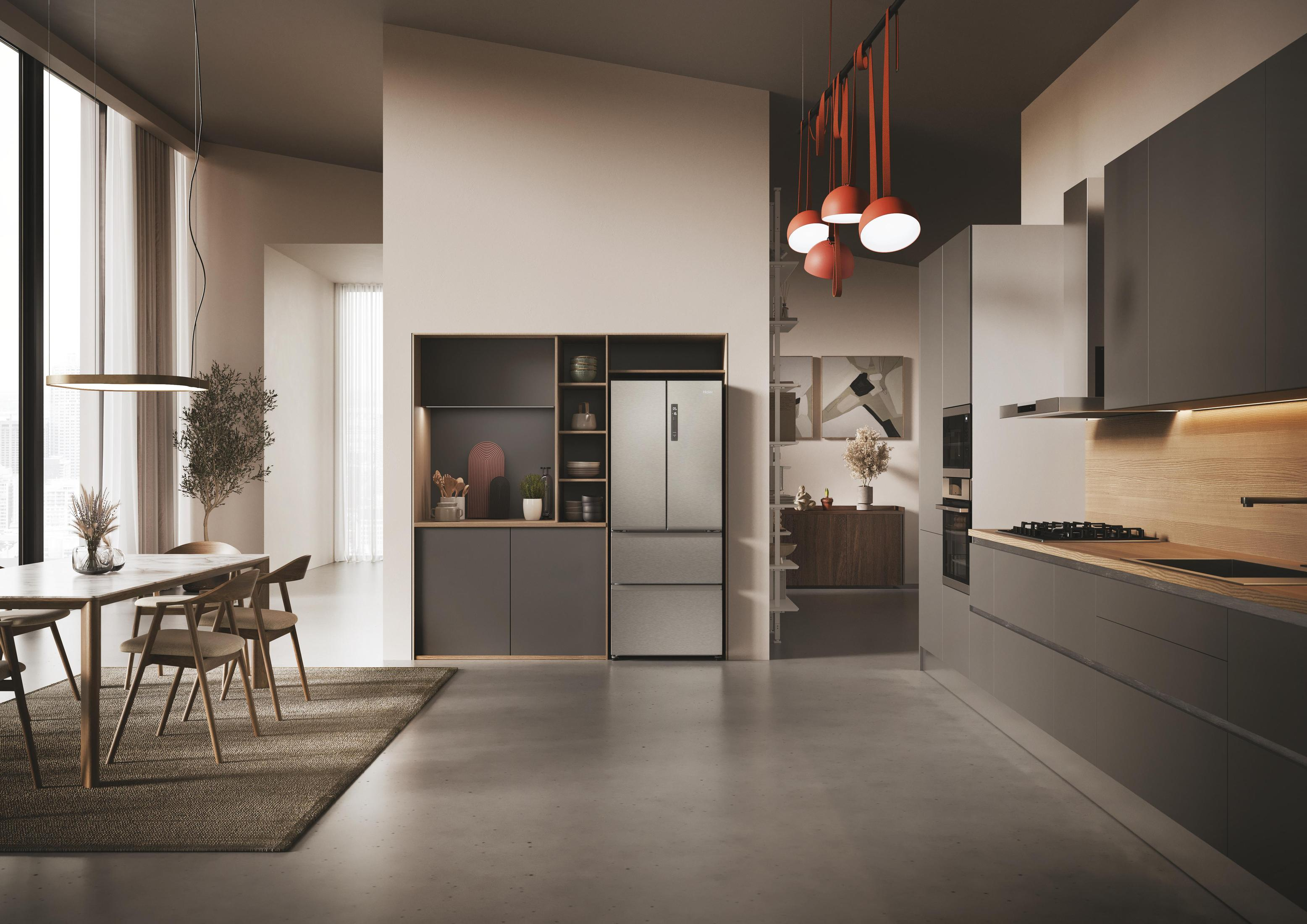 Een moderne keuken met grijze kasten, een roestvrijstalen koelkast en een eethoek.