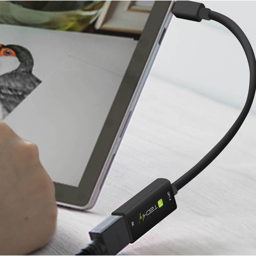 Un adaptador negro USB-C a HDMI conectado a una tableta, mostrando un dibujo de un pájaro.