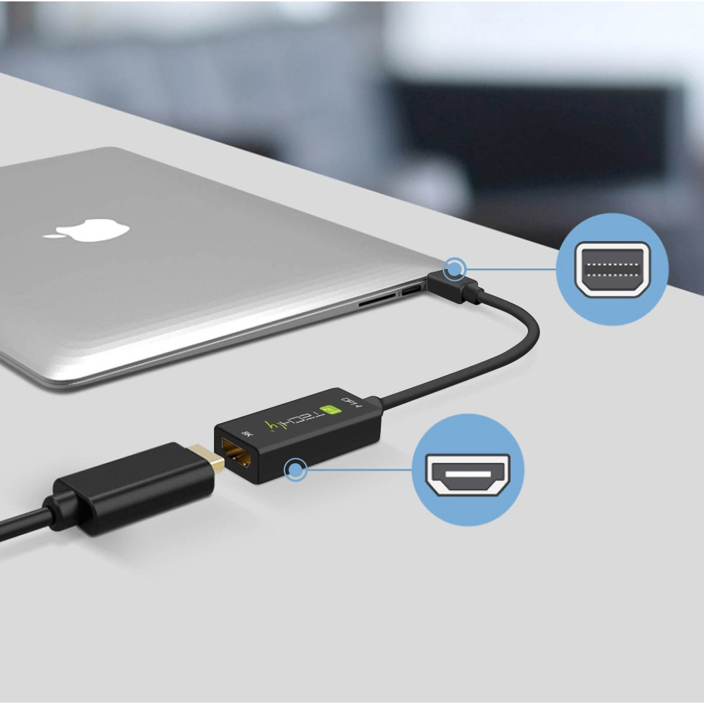 Cable adaptador negro conectando un portátil a una pantalla, con primer plano de puertos.