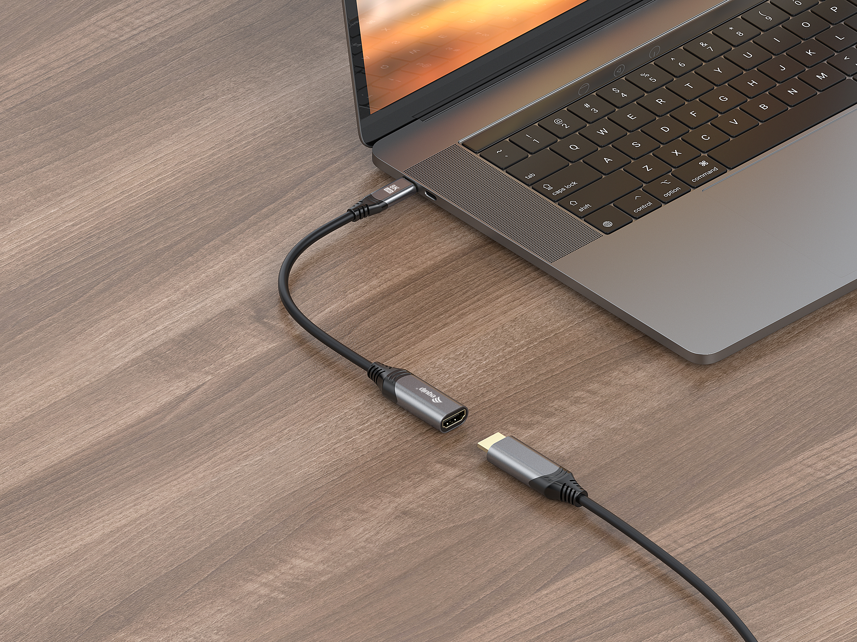 Laptop podłączony do kabla adaptera HDMI na drewnianej powierzchni.