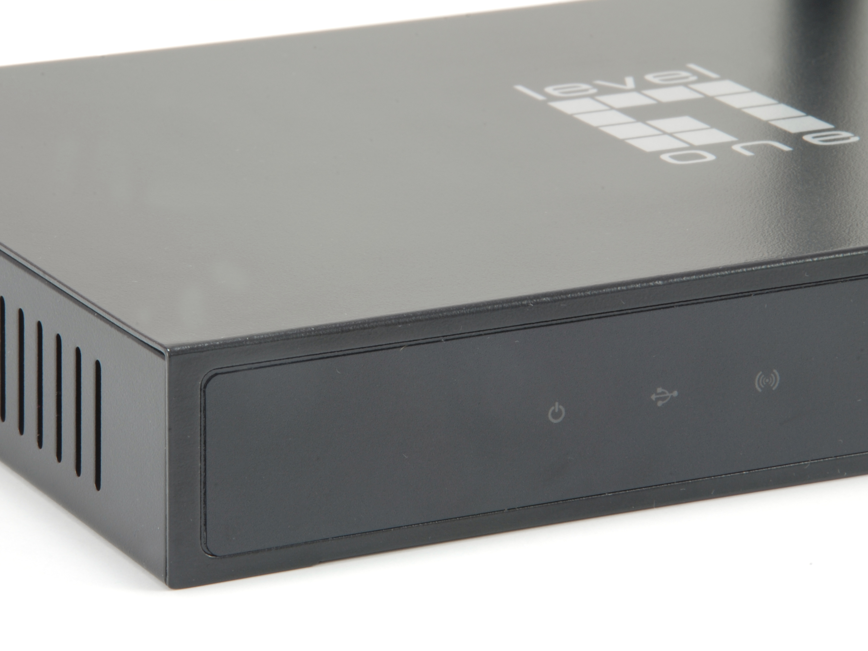 Close-up on a black device, with a power button and a USB port, white background.