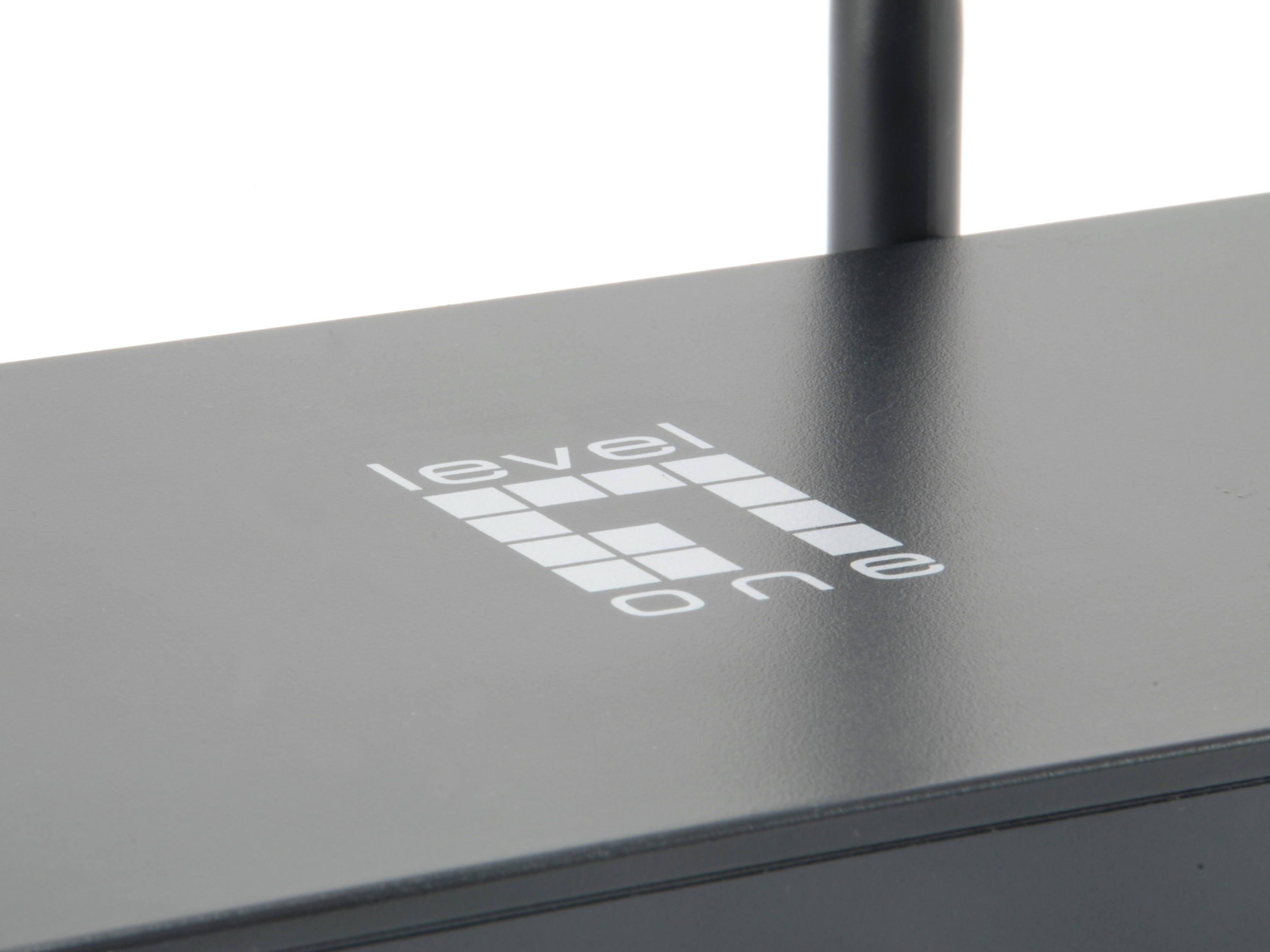Close-up of a black router, showing the Level One logo on the top, white background.