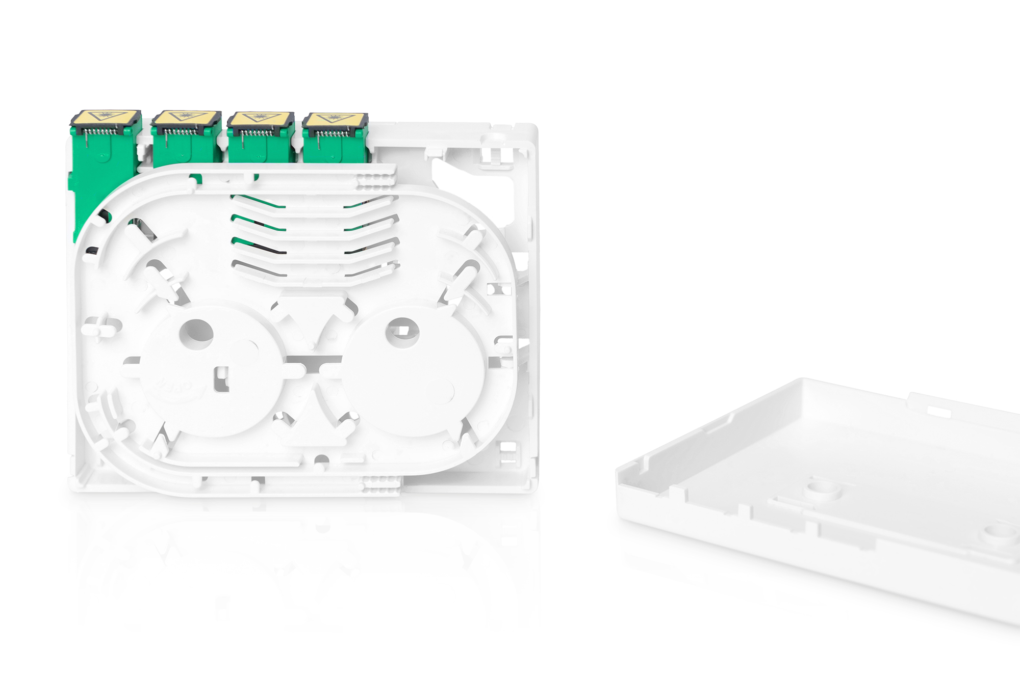 Białe plastikowe pudełko z zielonymi złączami w środku. Otwarte z pokrywą po prawej. Białe tło.