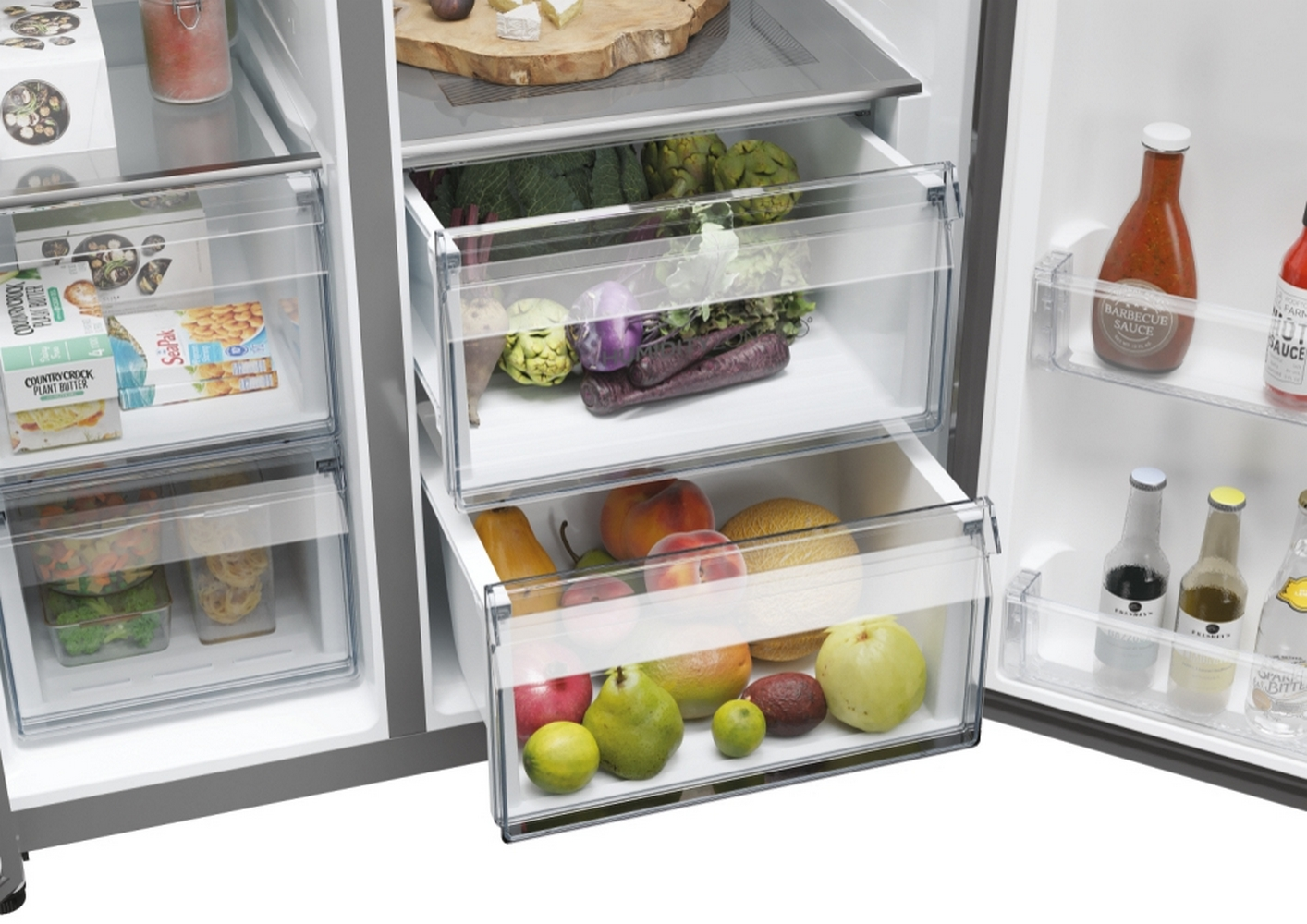 Interior de refrigerador con productos frescos: frutas, verduras y botellas de salsa.