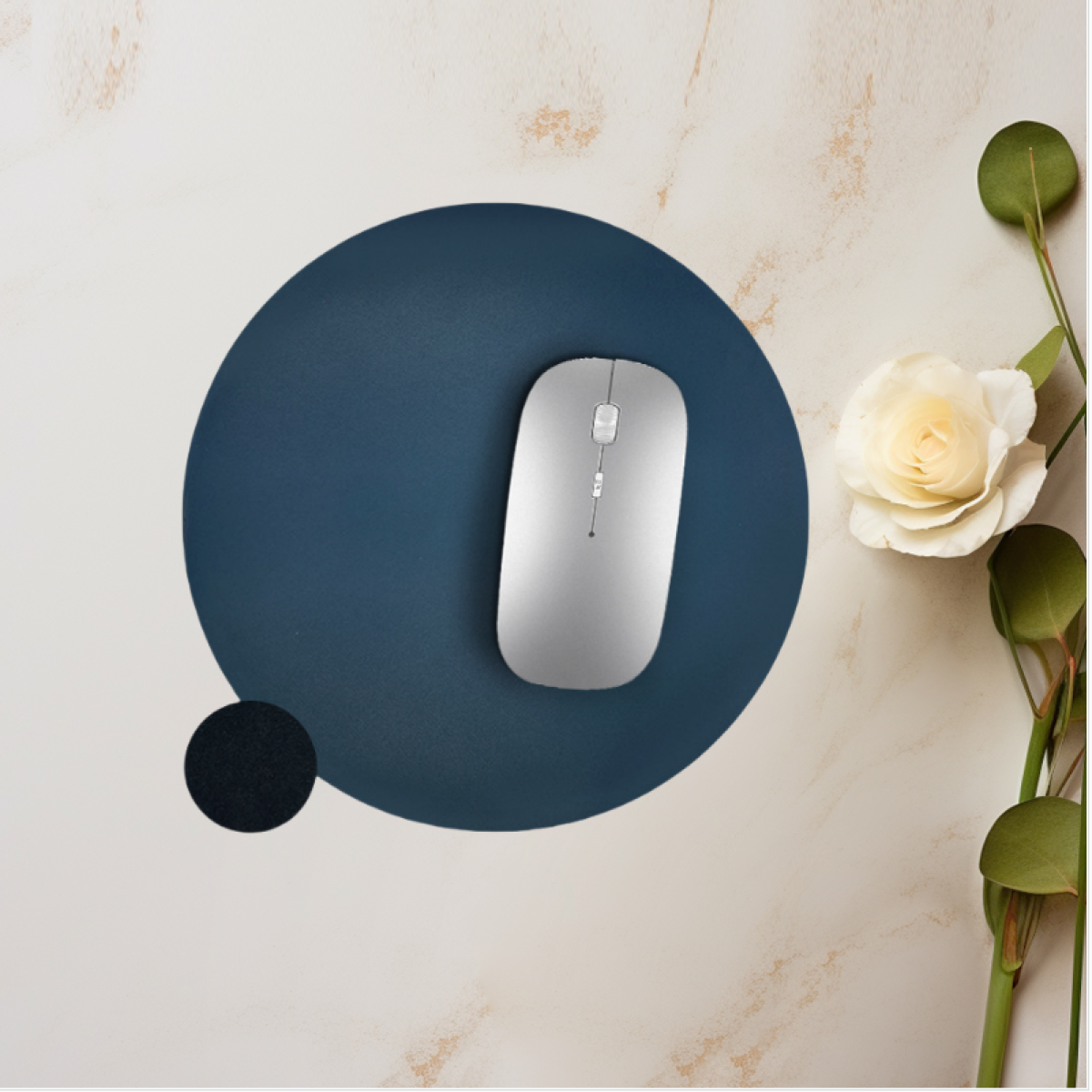 Un mouse wireless argento su un tappetino blu scuro, con un piccolo cerchio nero e sfondo bianco.