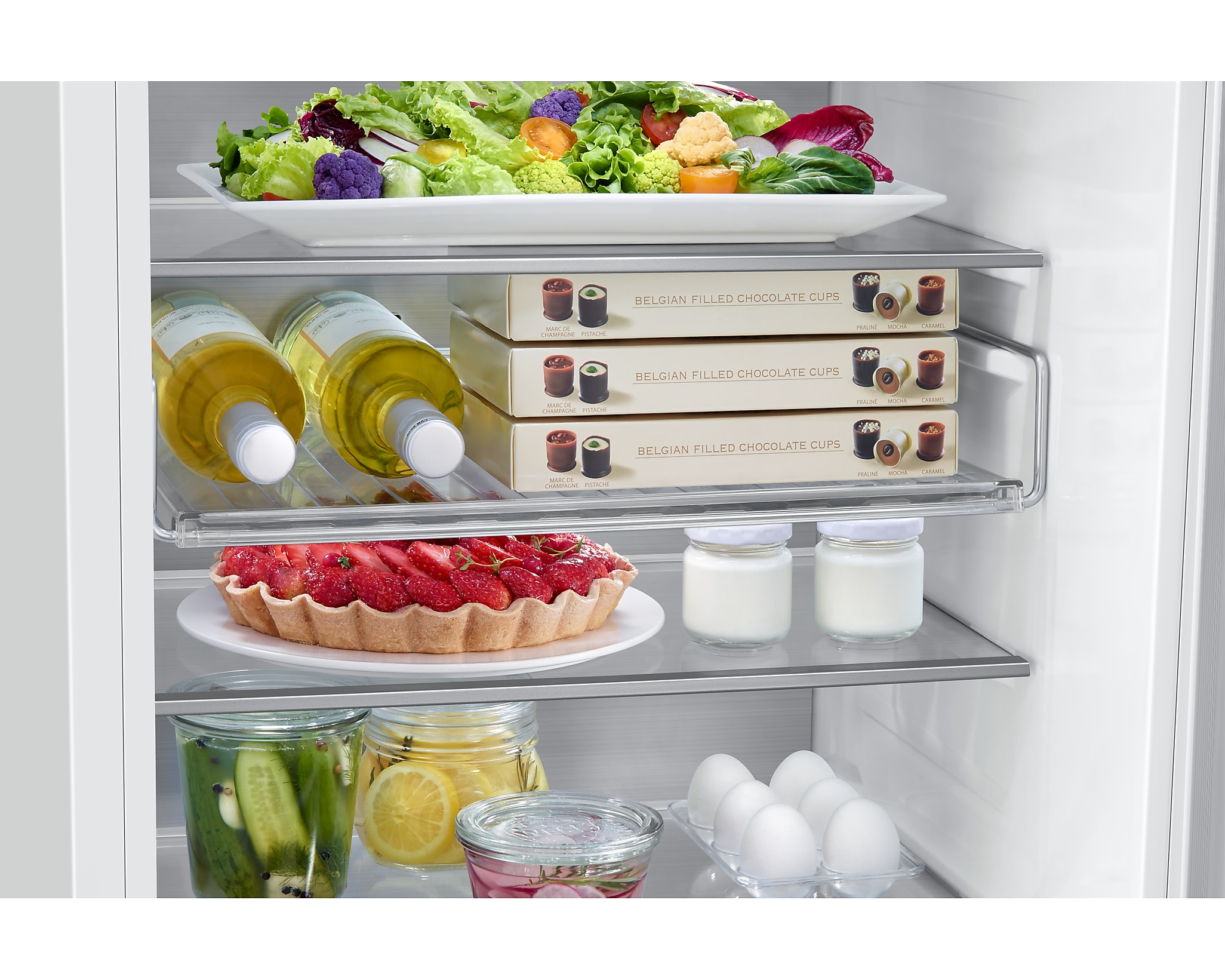 Zbliżenie wnętrza lodówki z różnymi produktami spożywczymi, w tym sałatą i jajkami.