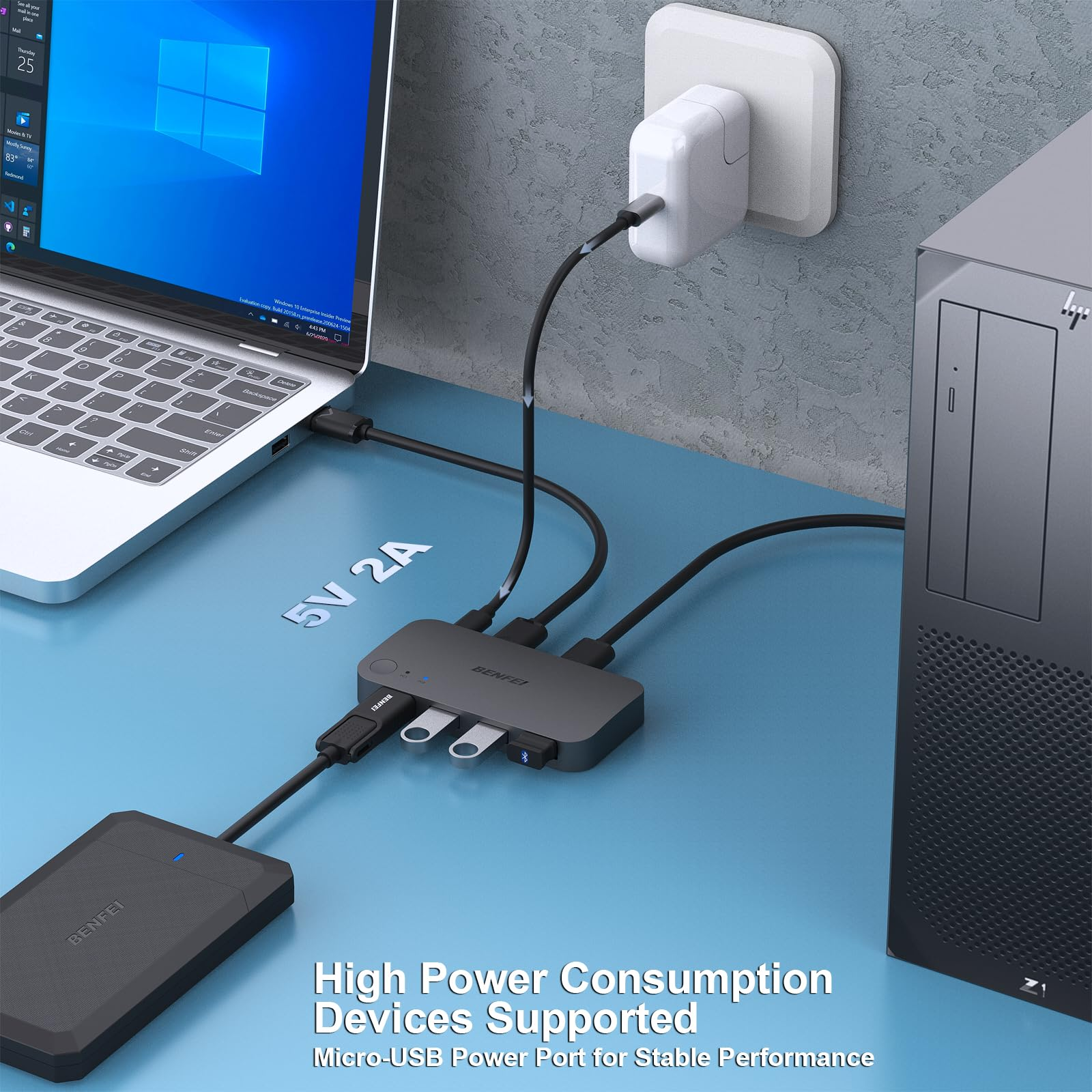 Laptop und USB-Hub verbunden. Text zeigt 5V 2A. Desktop und Steckdose im Hintergrund.