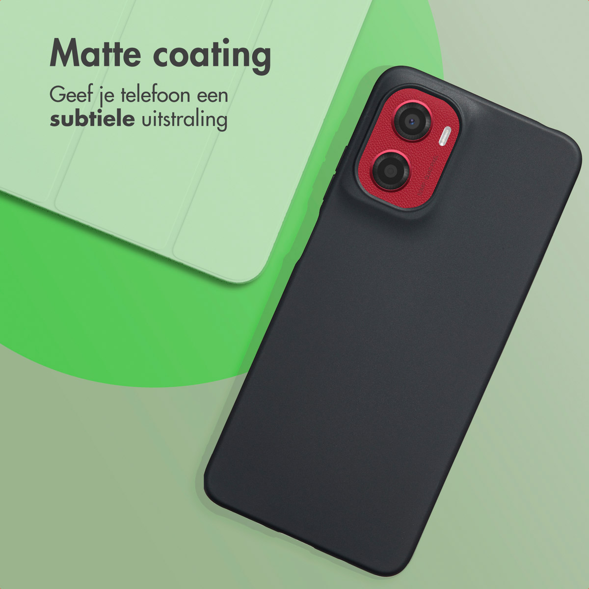 Une coque de téléphone noire avec une zone de caméra rouge, placée sur une surface verte. Une autre coque en arrière-plan.