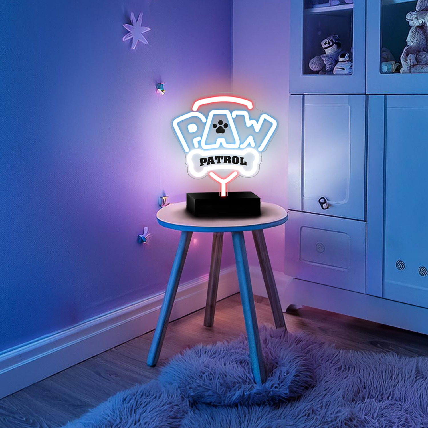 Kolorowy neon z logo Paw Patrol na małym stoliku, w pokoju dziecięcym z zabawkami i miękkim oświetleniem.
