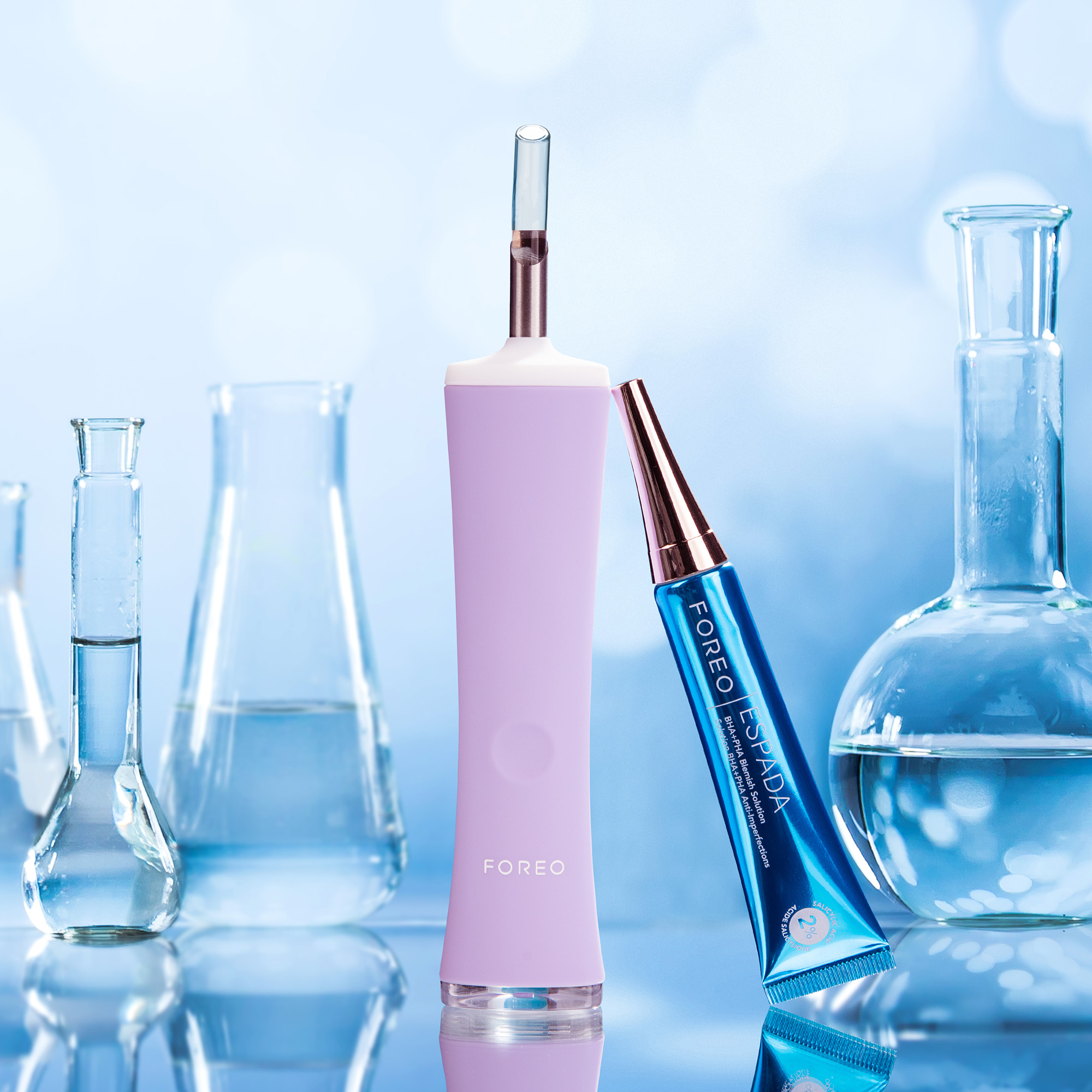 Purple beauty device and cosmetic products. Laboratory background.