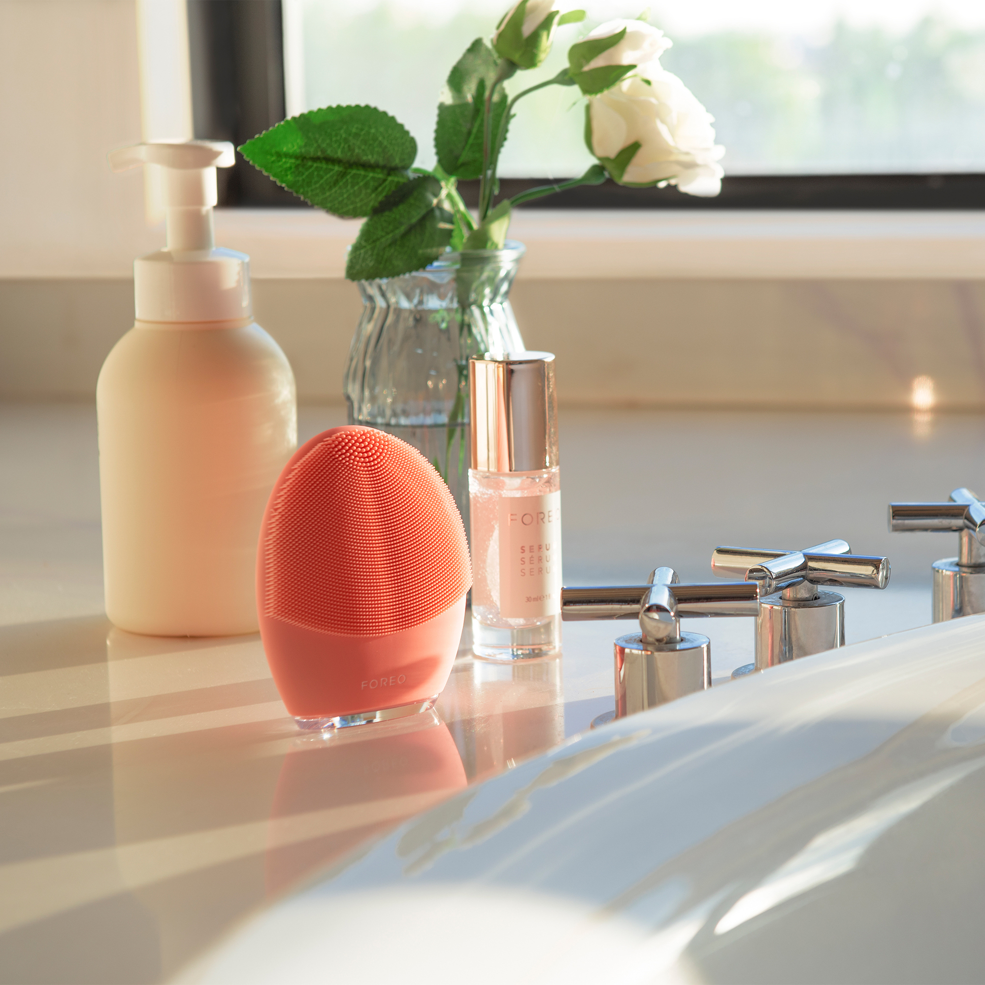Bathroom scene with a Foreo device, serum bottle, and other items.
