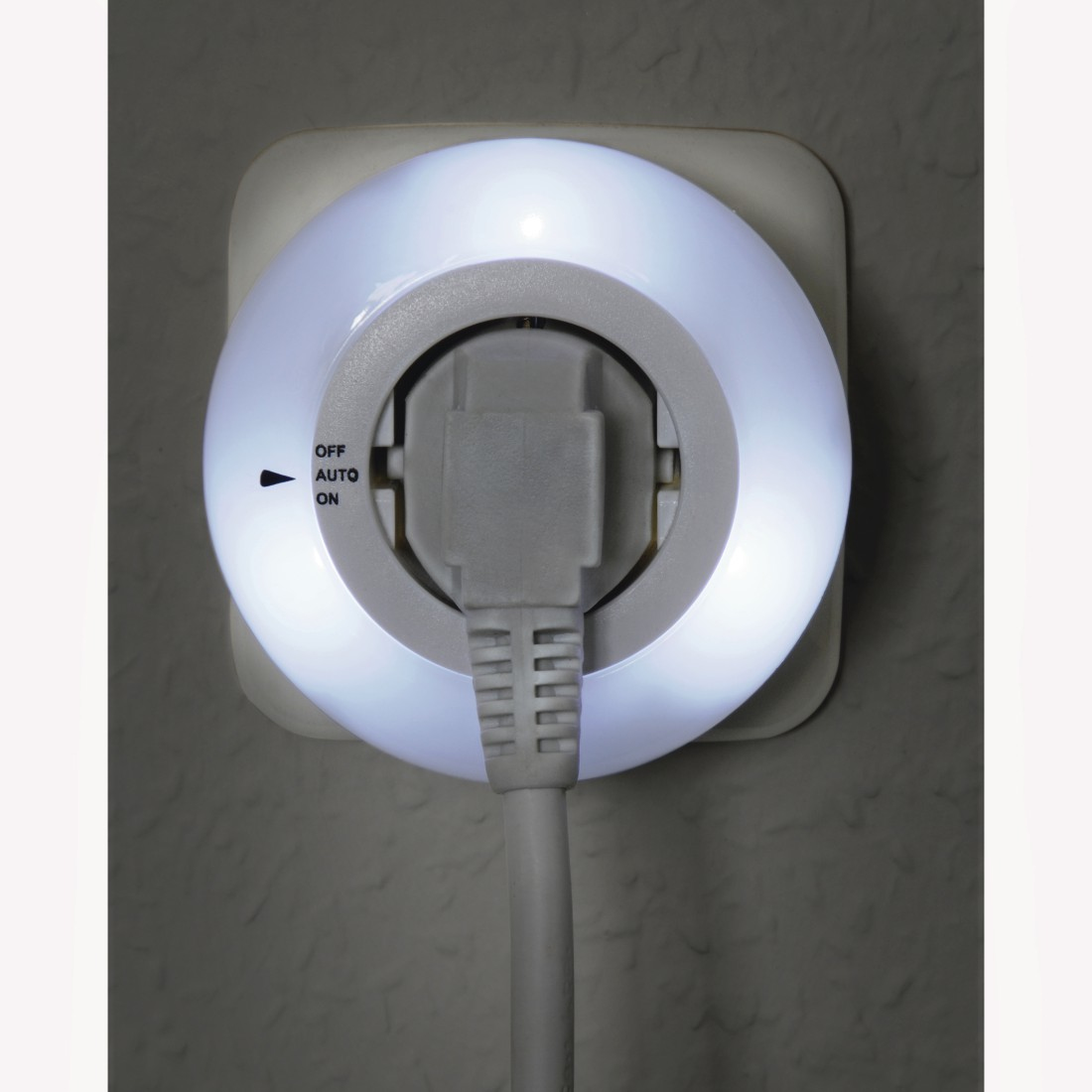 Ein weißes Licht, das aus einer Steckdose kommt. Ein Stecker ist eingesetzt, mit einem Aus-Automatik-Ein-Schalter.
