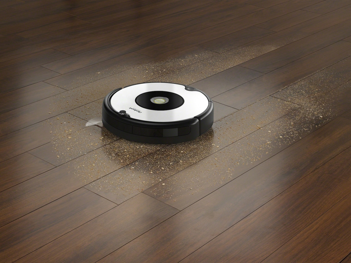 Odkurzacz robot sprzątający drewnianą podłogę, z rozrzuconym brudem wokół.