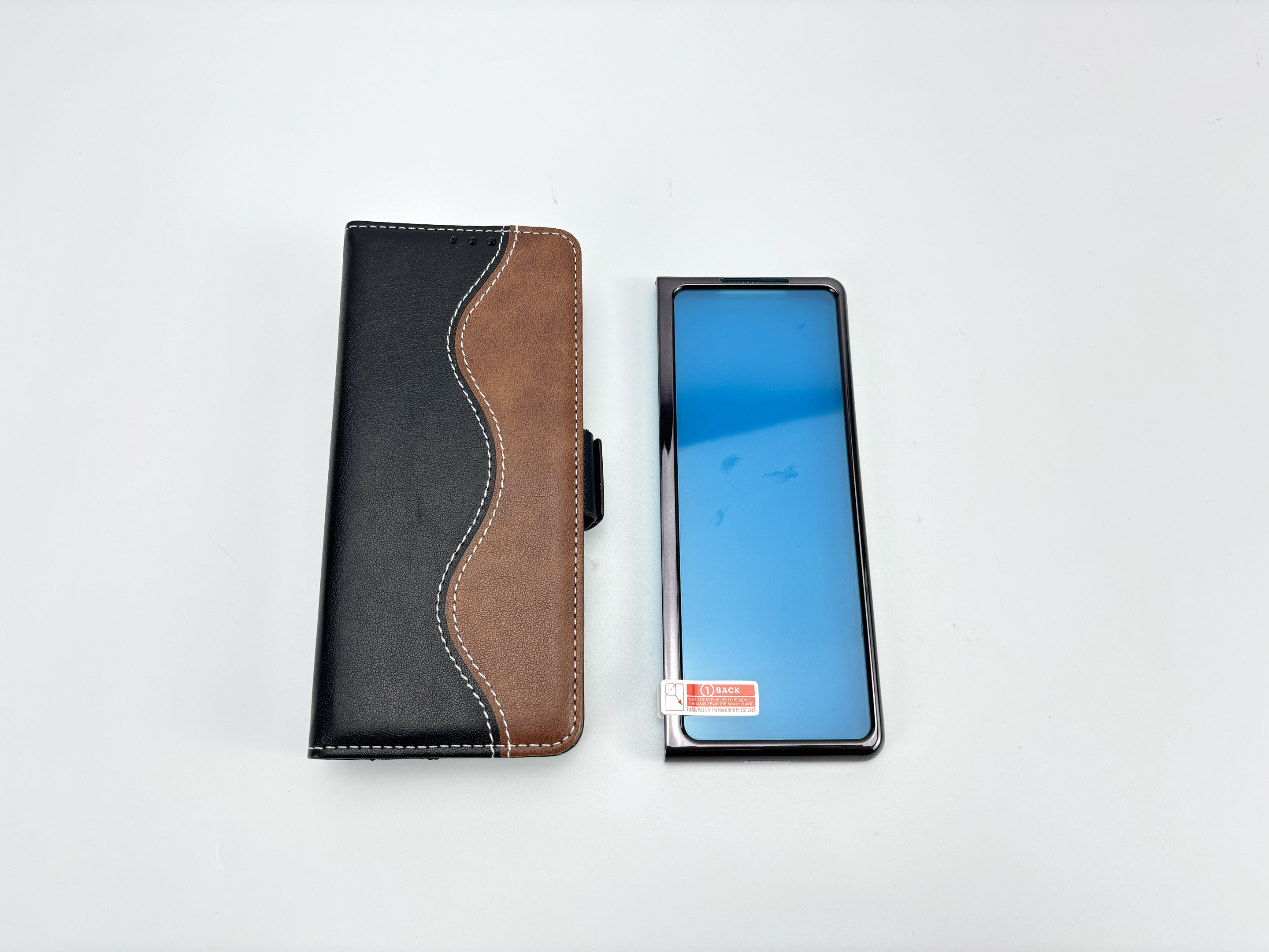 Una custodia per telefono aperta accanto a un telefono con protezione schermo blu. Sfondo bianco.