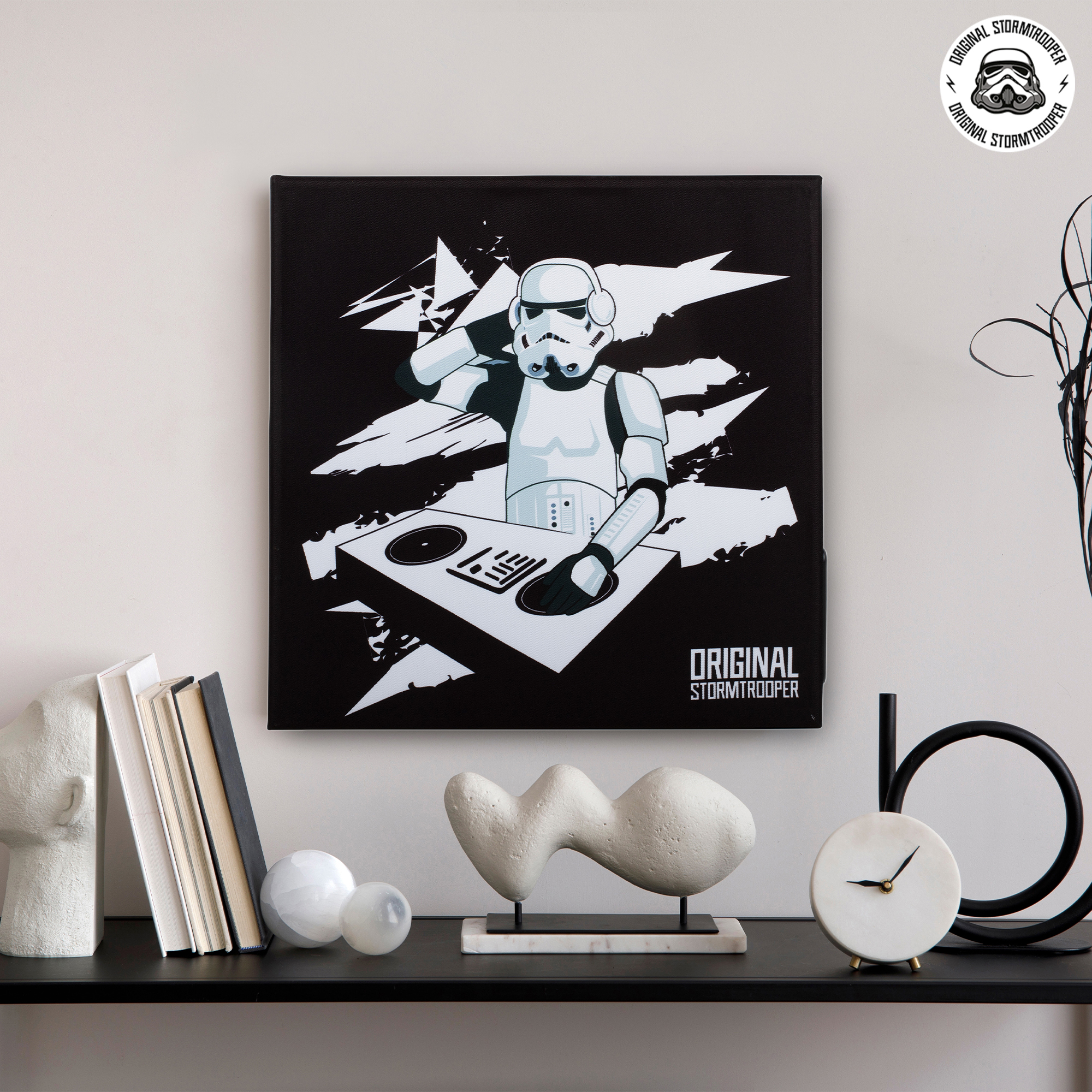 Stormtrooper DJ-kunst aan de muur. Boeken en decor op plank, zwart-wit thema.