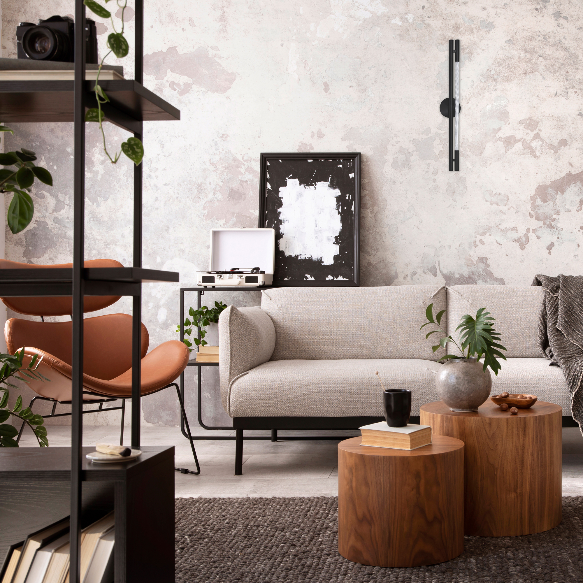 Un soggiorno con divano, libreria, tavolo e oggetti decorativi.