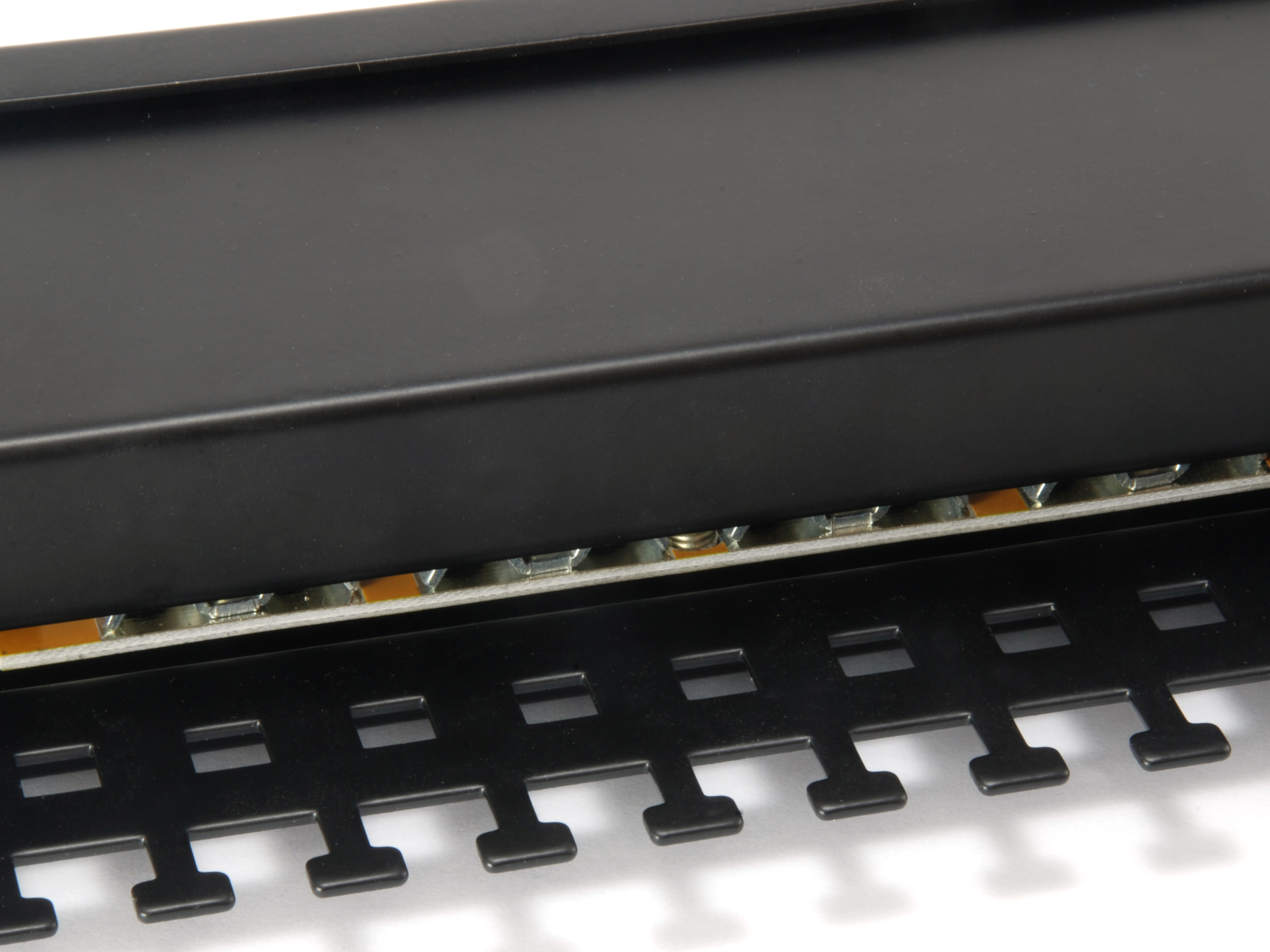 Zbliżenie czarnego metalowego panelu ze szczelinami i serią małych świateł.