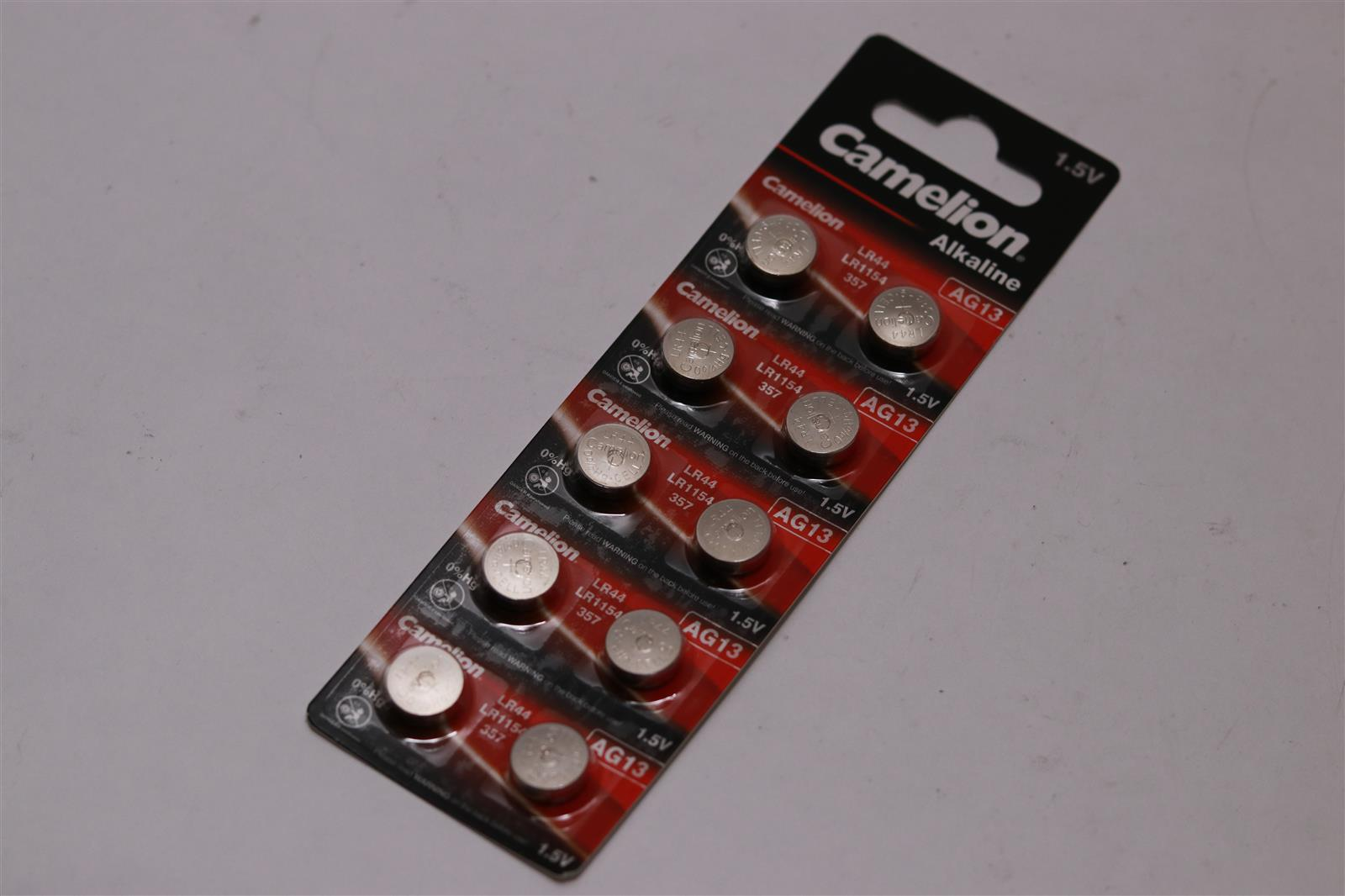 Opakowanie okrągłych baterii. Baterie są na czarno-czerwonej podstawie.