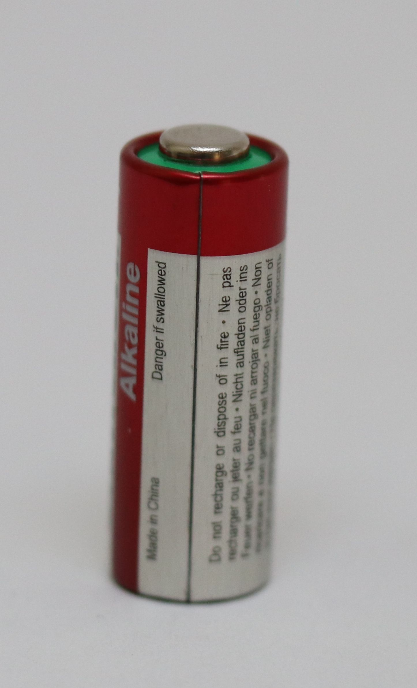 Czerwona i srebrna cylindryczna bateria z napisem "Alkaline" i tekstem ostrzegawczym. Napis "Made in China" jest wydrukowany z boku.